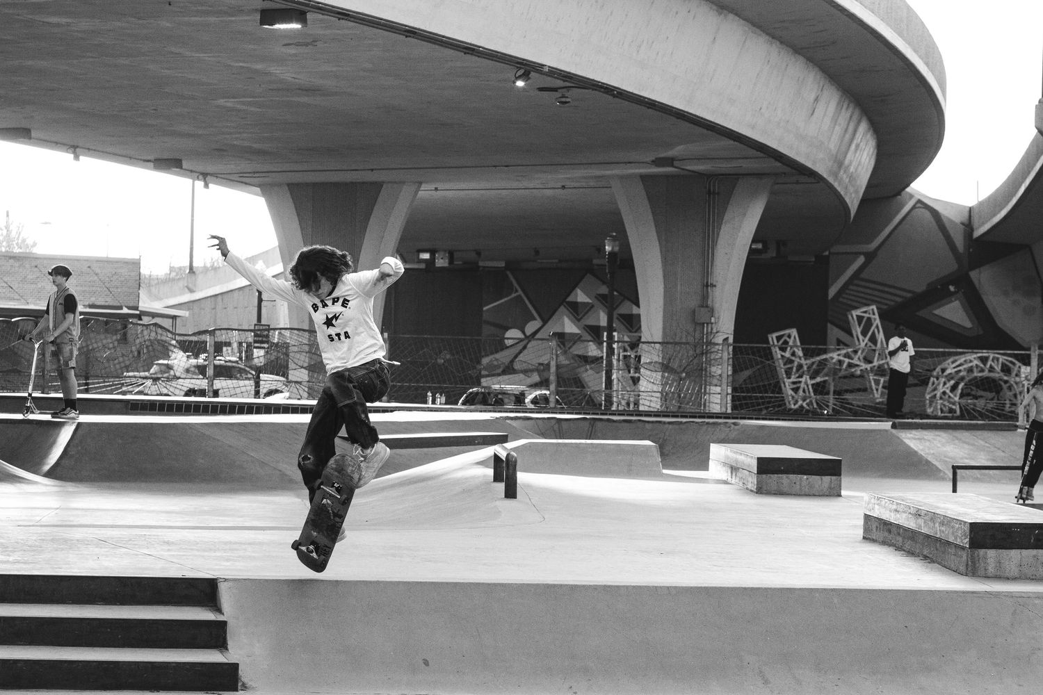 black and white photo shows young skate boarder doing a telling trick in this urban concrete park located in Boise Idaho