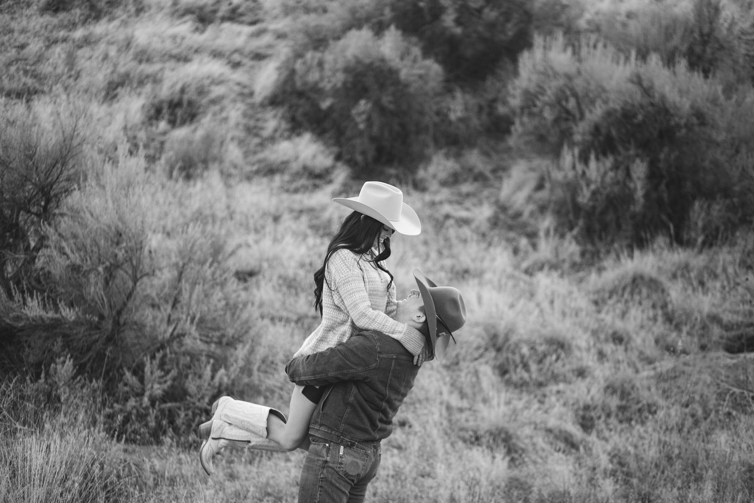 Couple dance together as they celebrate engagement with each other in this black and white landscape photo in eagle Idaho