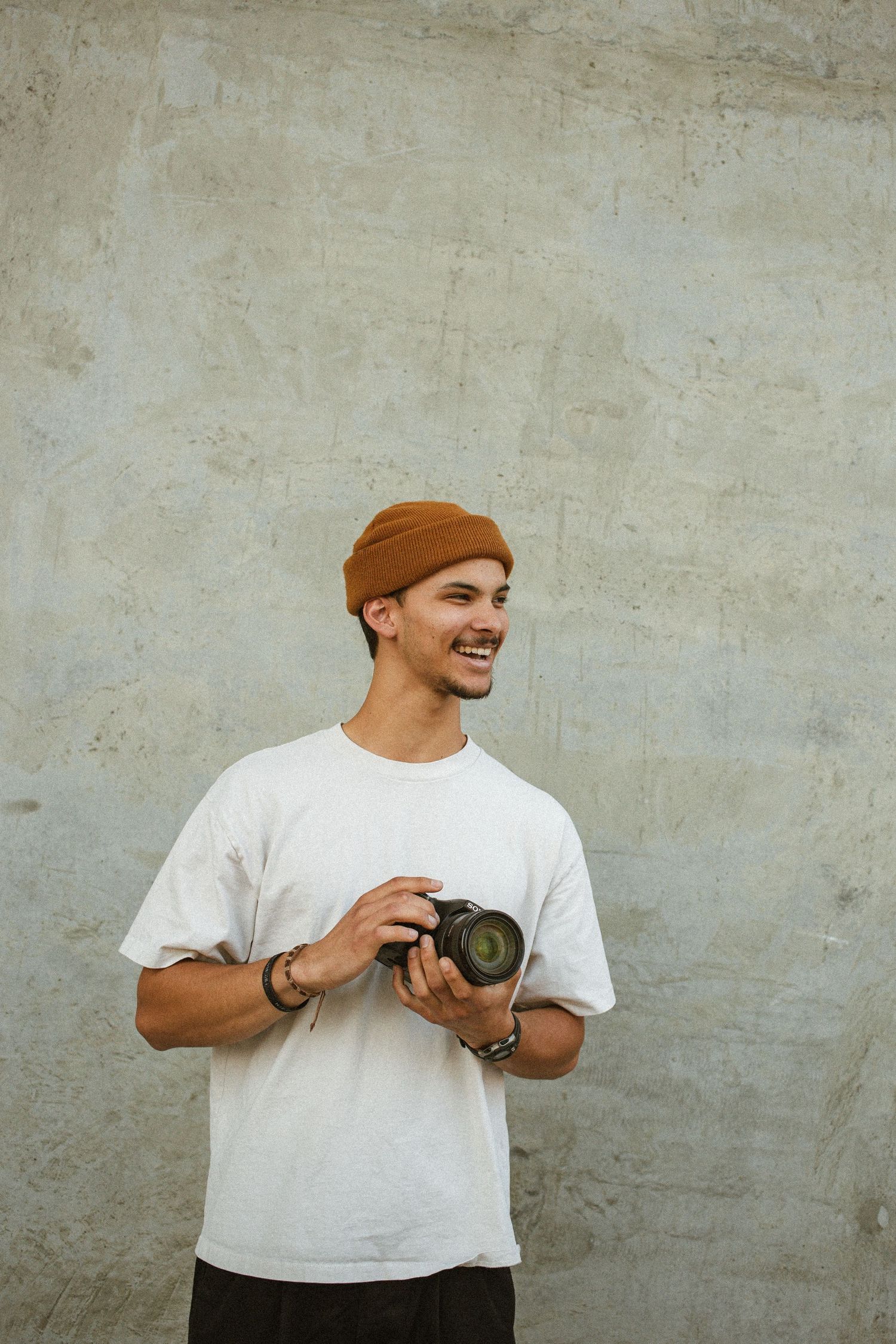 A young man poses as he gets his head shots taken whit his camera in a concrete setting in boise Idaho