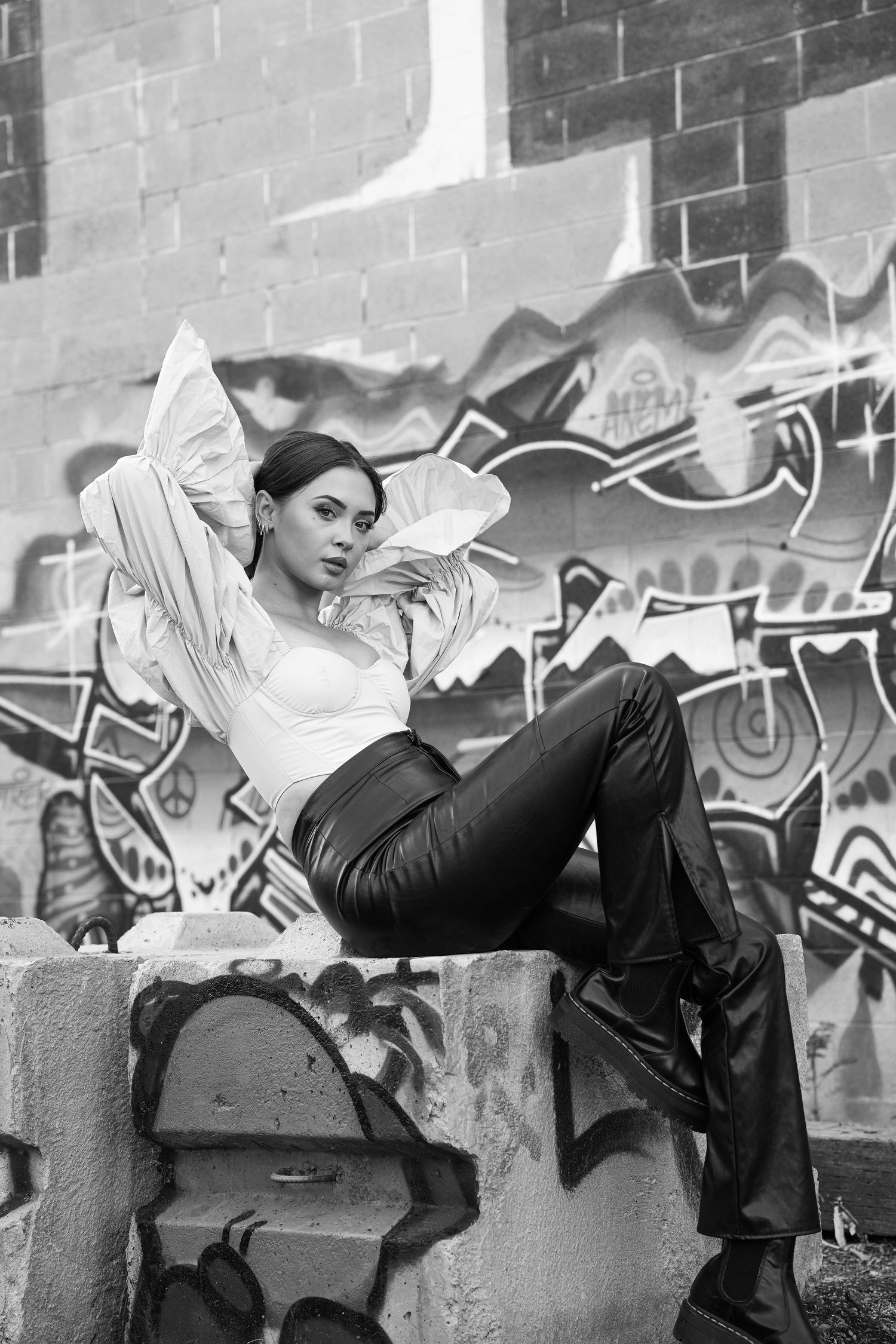 model possess on a cement block in a industrial ally wearing a chic outfit in Salt Lake City