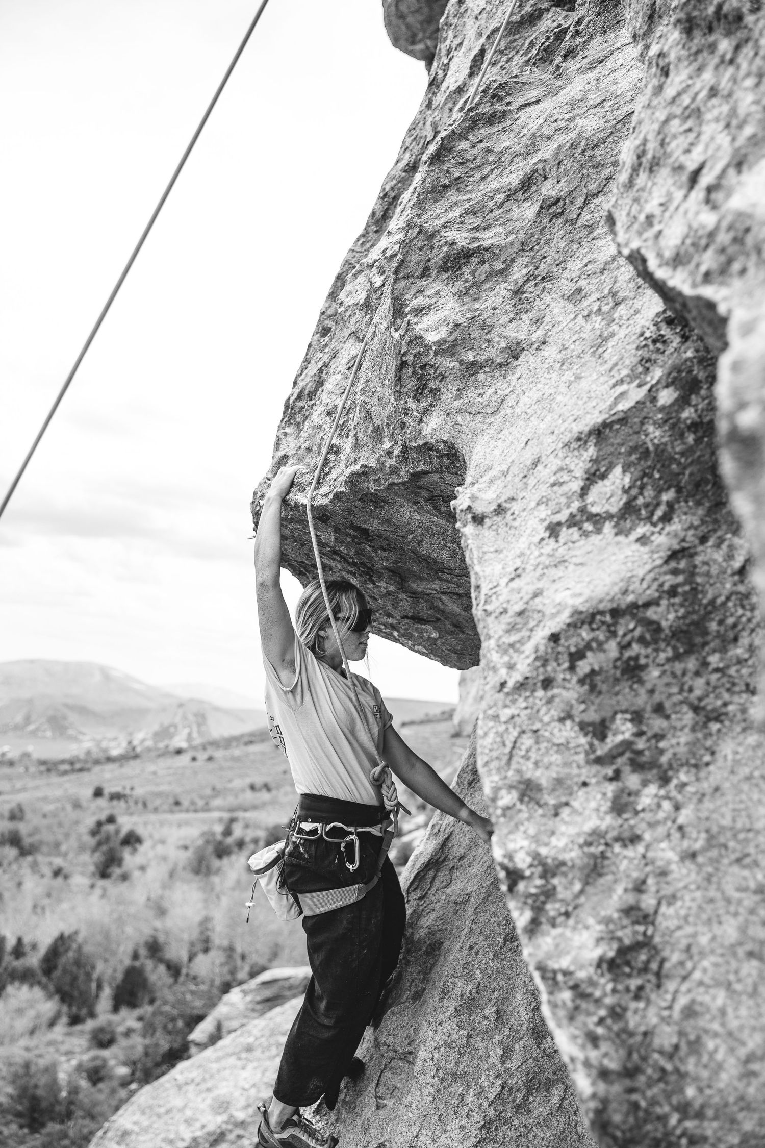 Rock climber scales challenging limestone cliff face while bouldering outdoors in mountainous terrain.