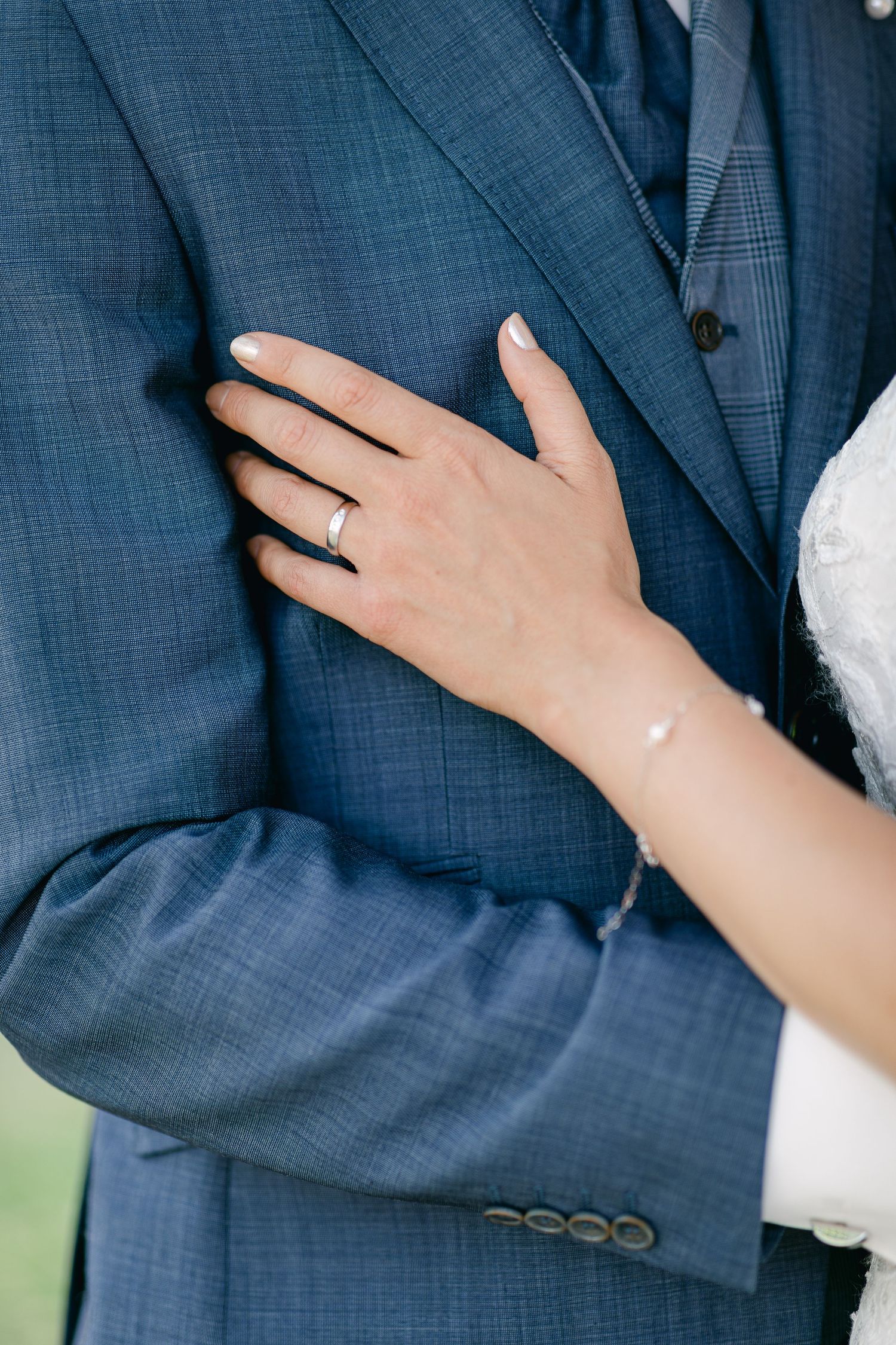 Close-up details of a navy blue wedding suit with a hand wearing an engagement ring.Luxembourg wedding photographer