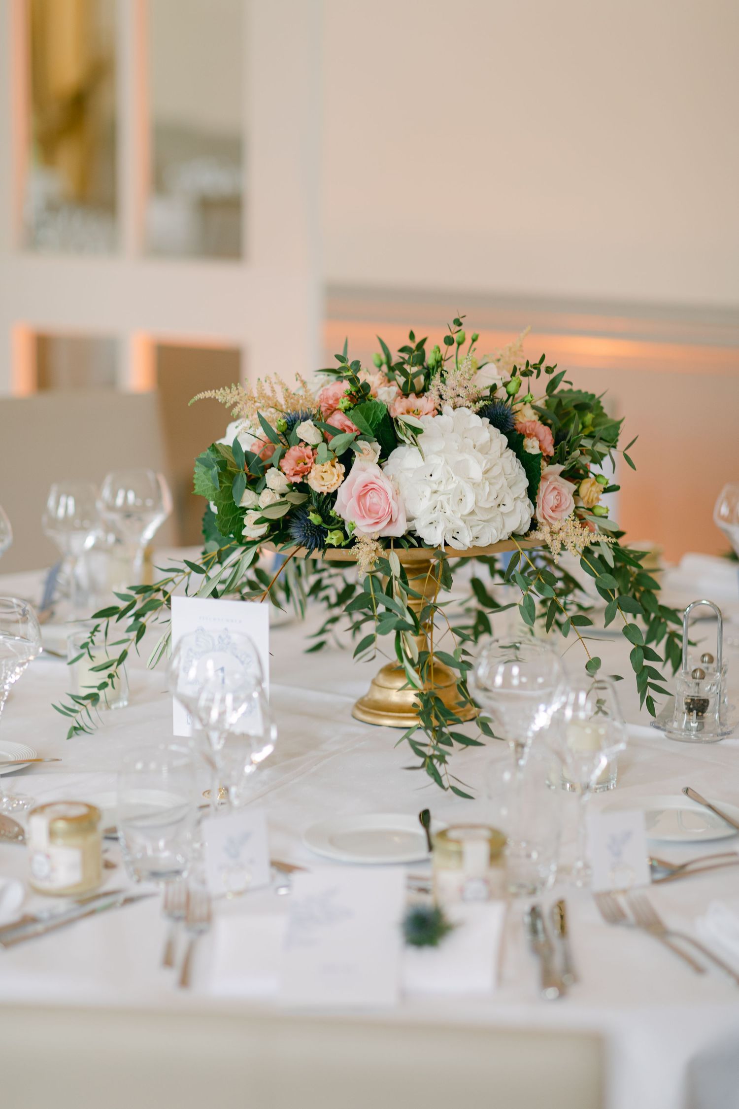 Elegant wedding table settings with pink and white floral centerpieces and crystal glassware. Luxembourg wedding photographer