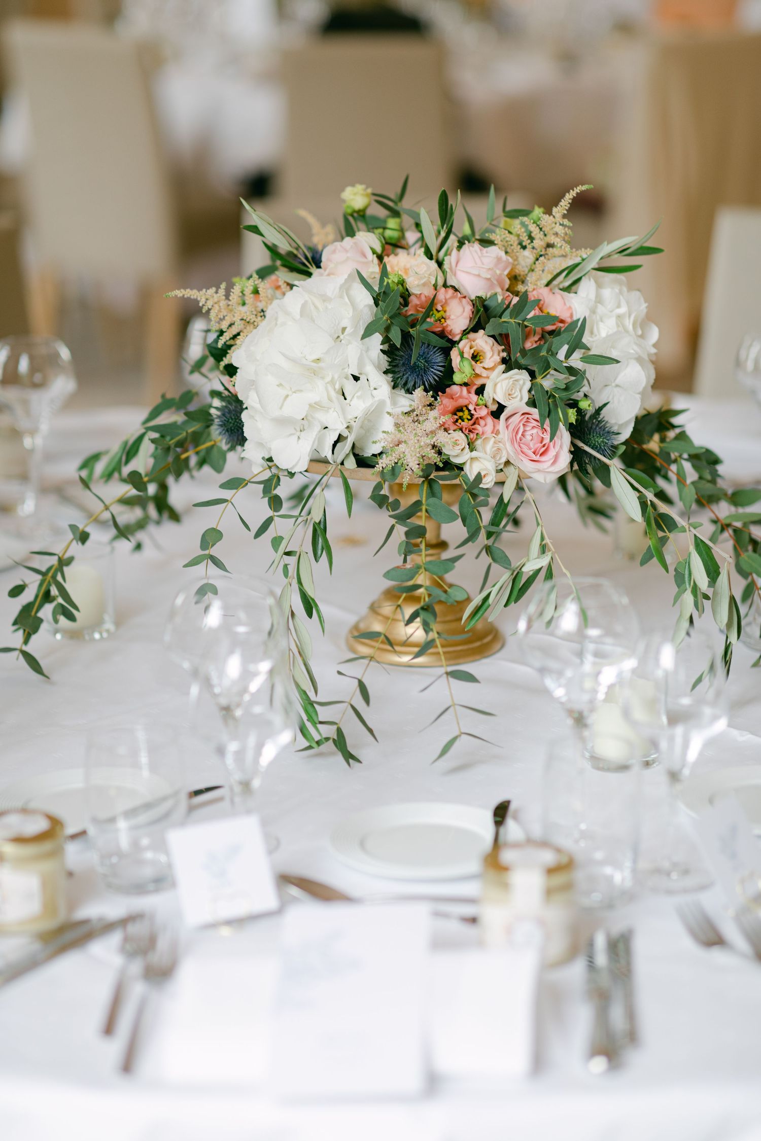 Elegant wedding reception table settings with delicate floral centerpieces and white linens.