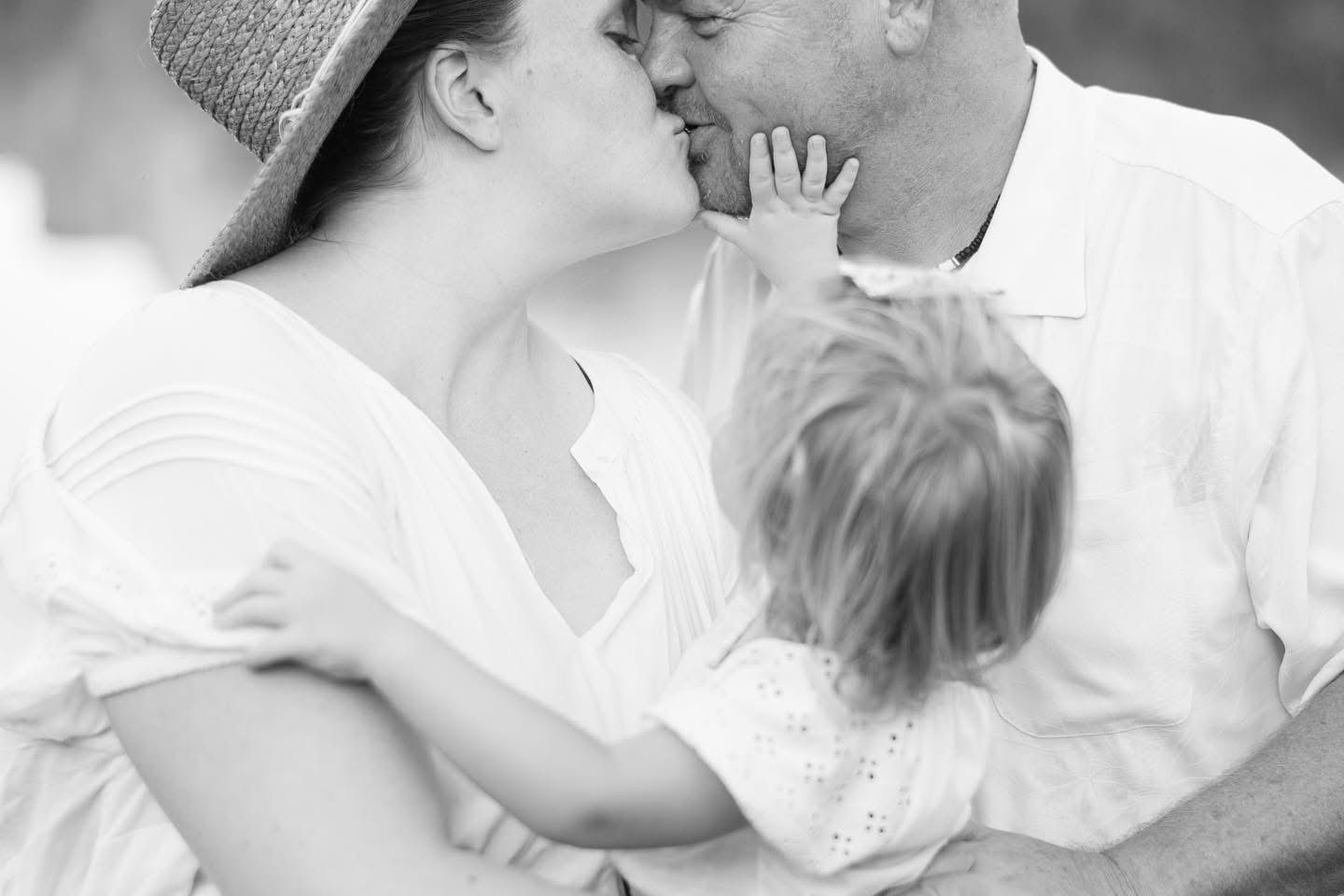 Sweet black and white family moment captured during outdoor photo session.