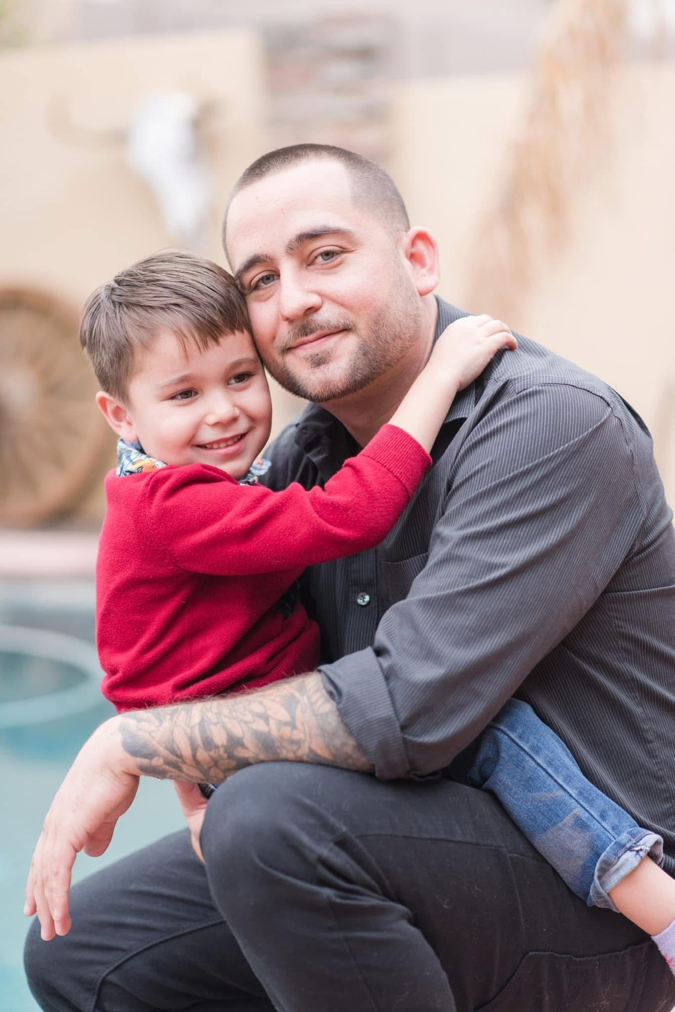 Parent and child sharing a warm embrace and smiling next to a pool.