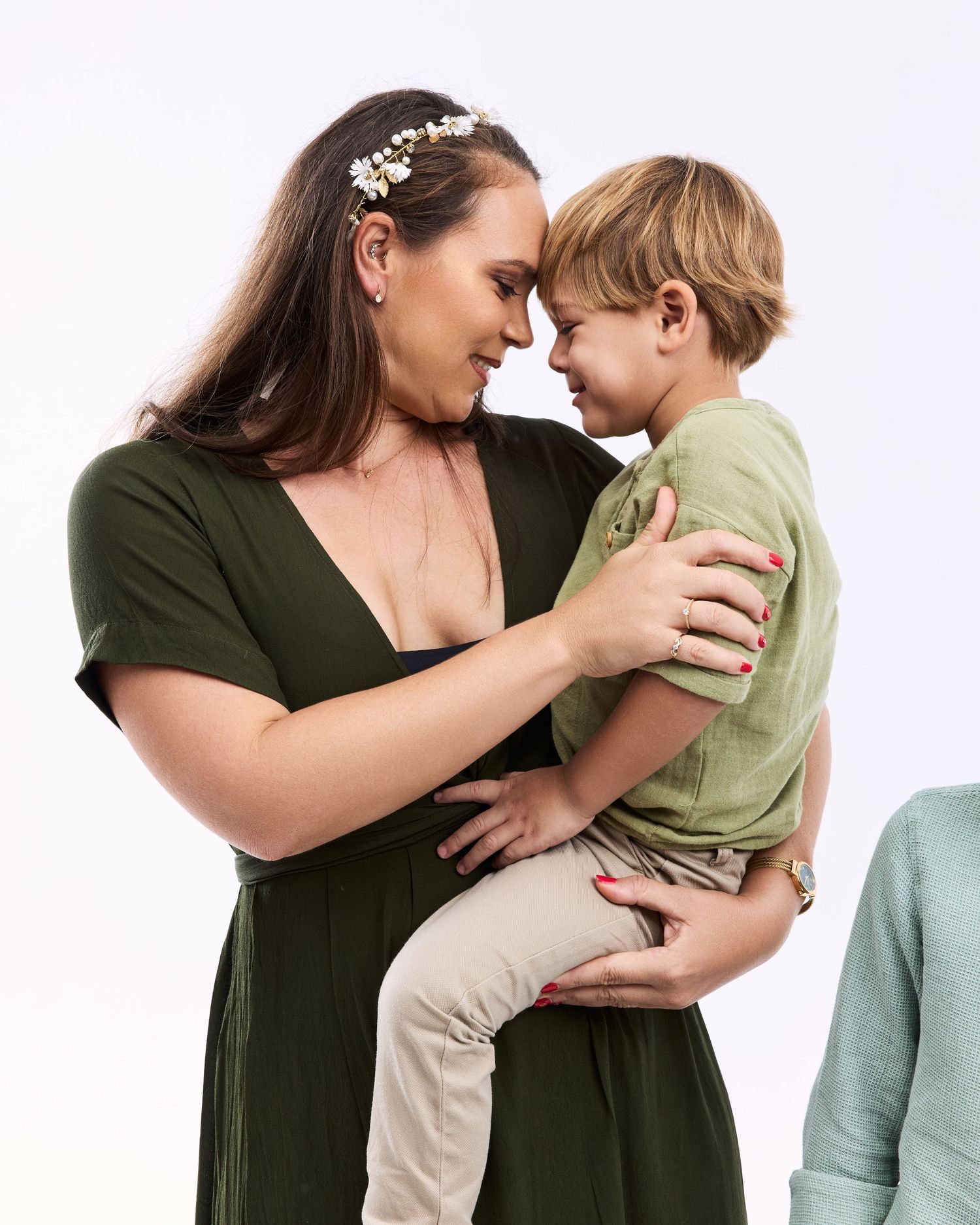 Tender moment between parent and child in casual clothing against white background.