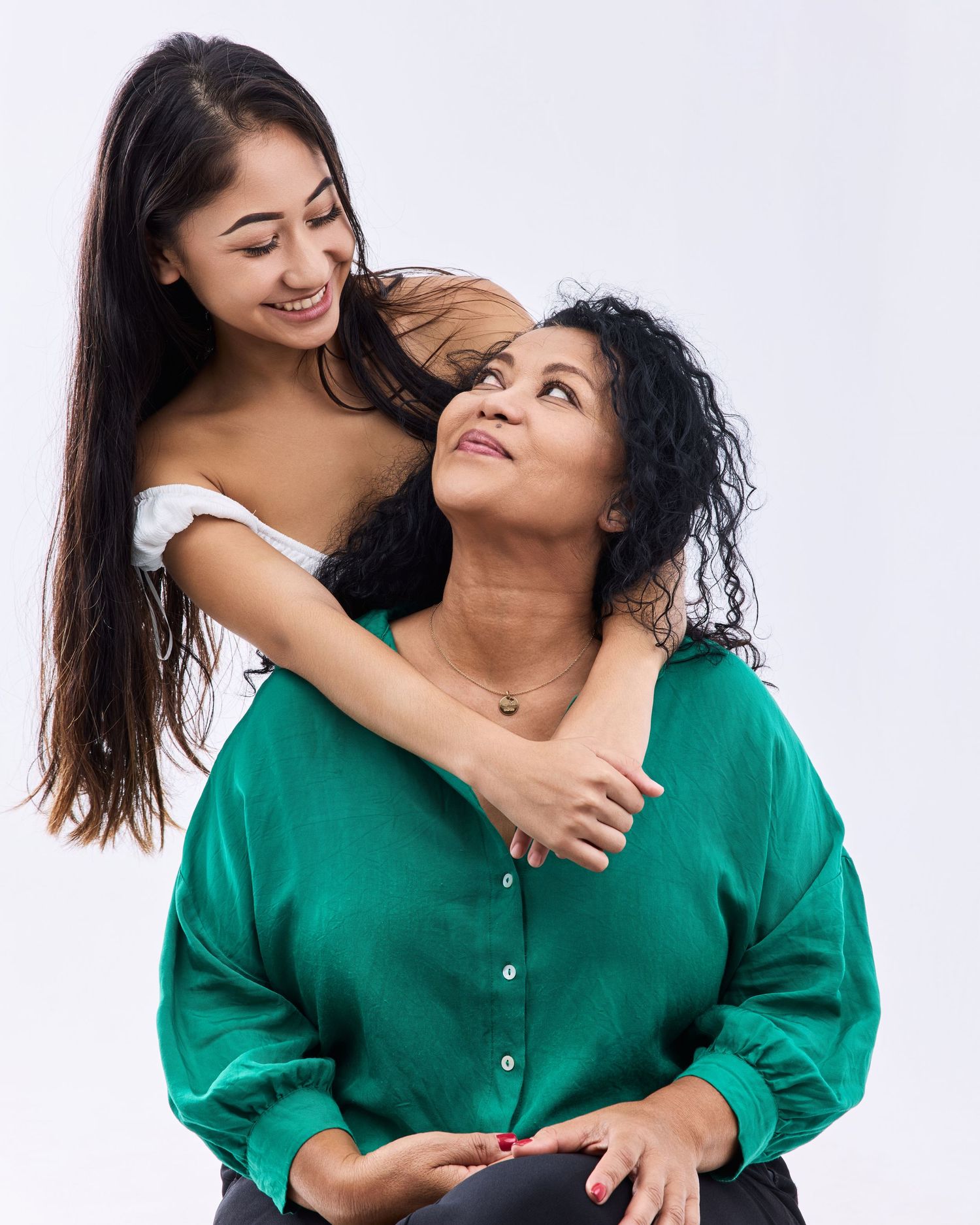 Two people in green tops share joyful moments in studio photoshoot series.