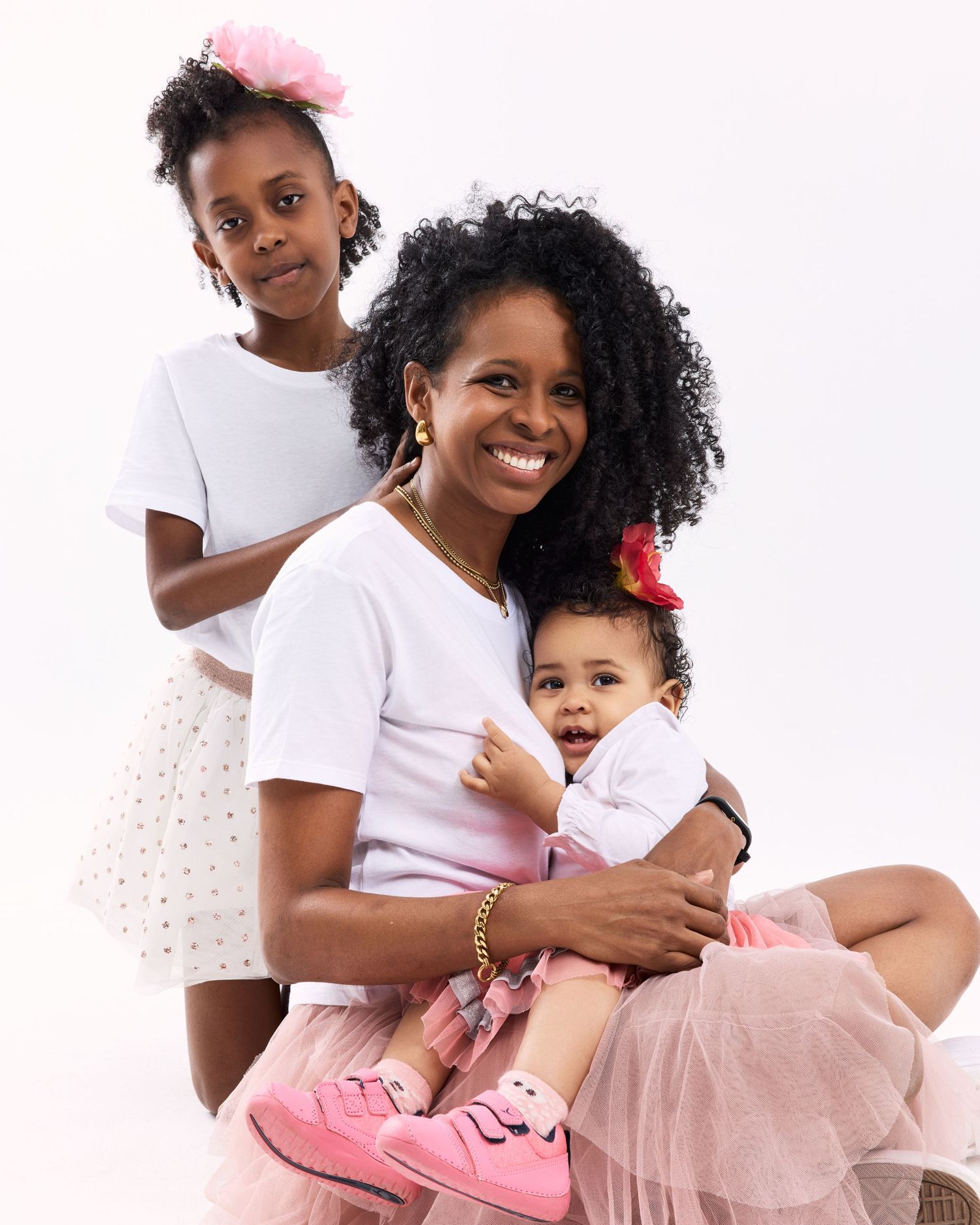 Mother and child in pink tulle outfits pose together for studio portraits.
