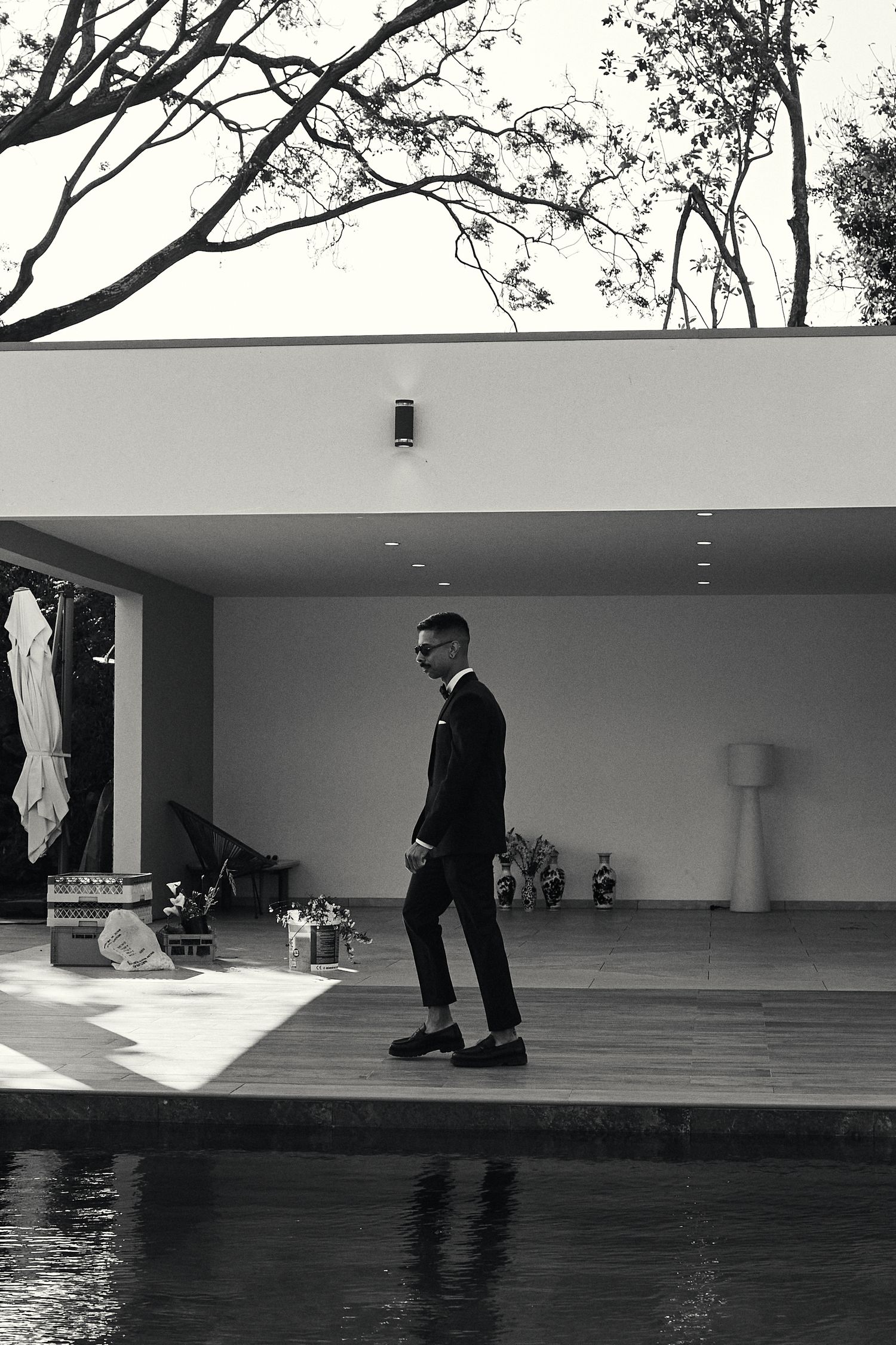 Black and white minimalist photos of person cleaning outdoor deck by pool.