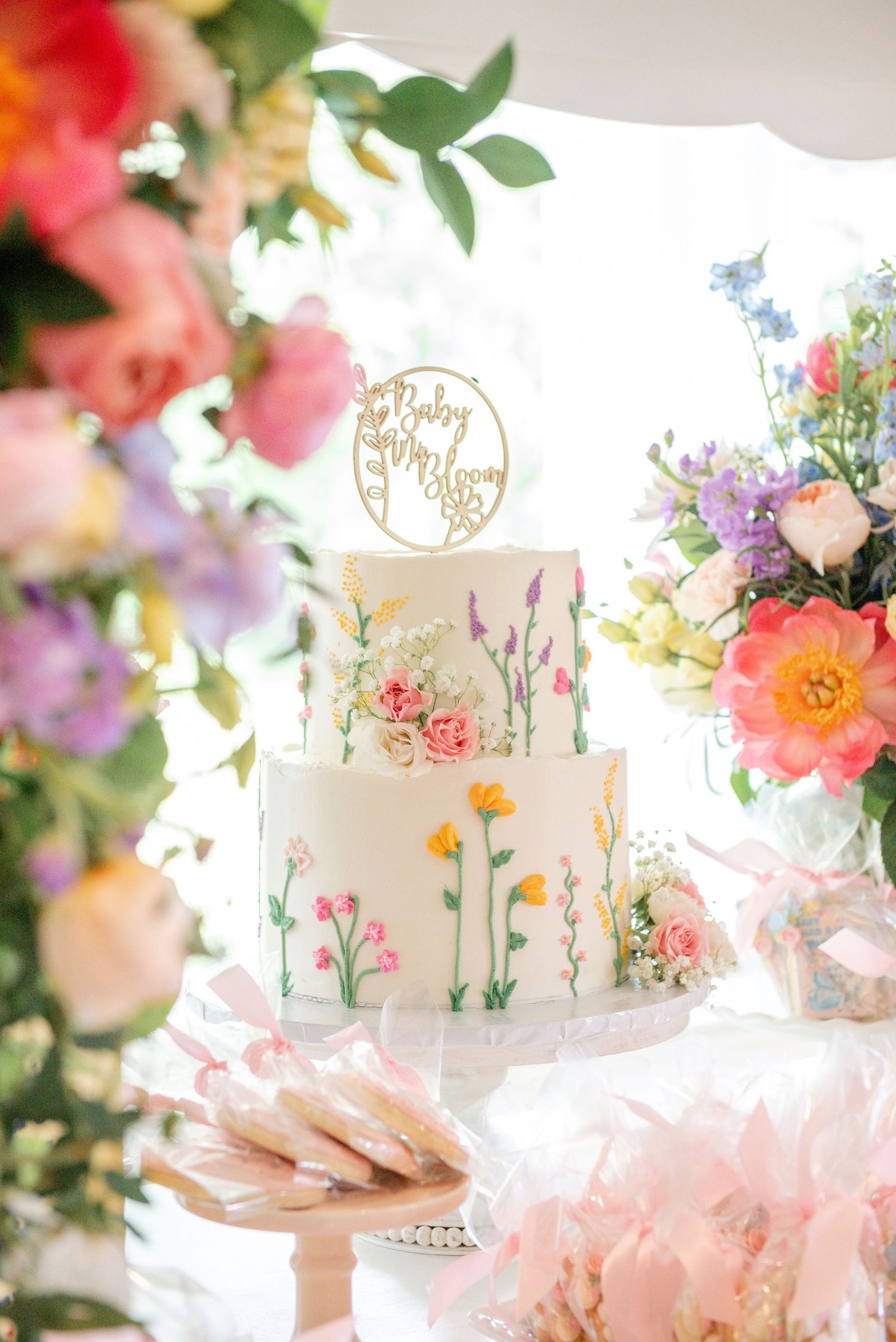 Elegant sweet cart with delicate floral arrangements and pastel decorations in soft pink and white tones.