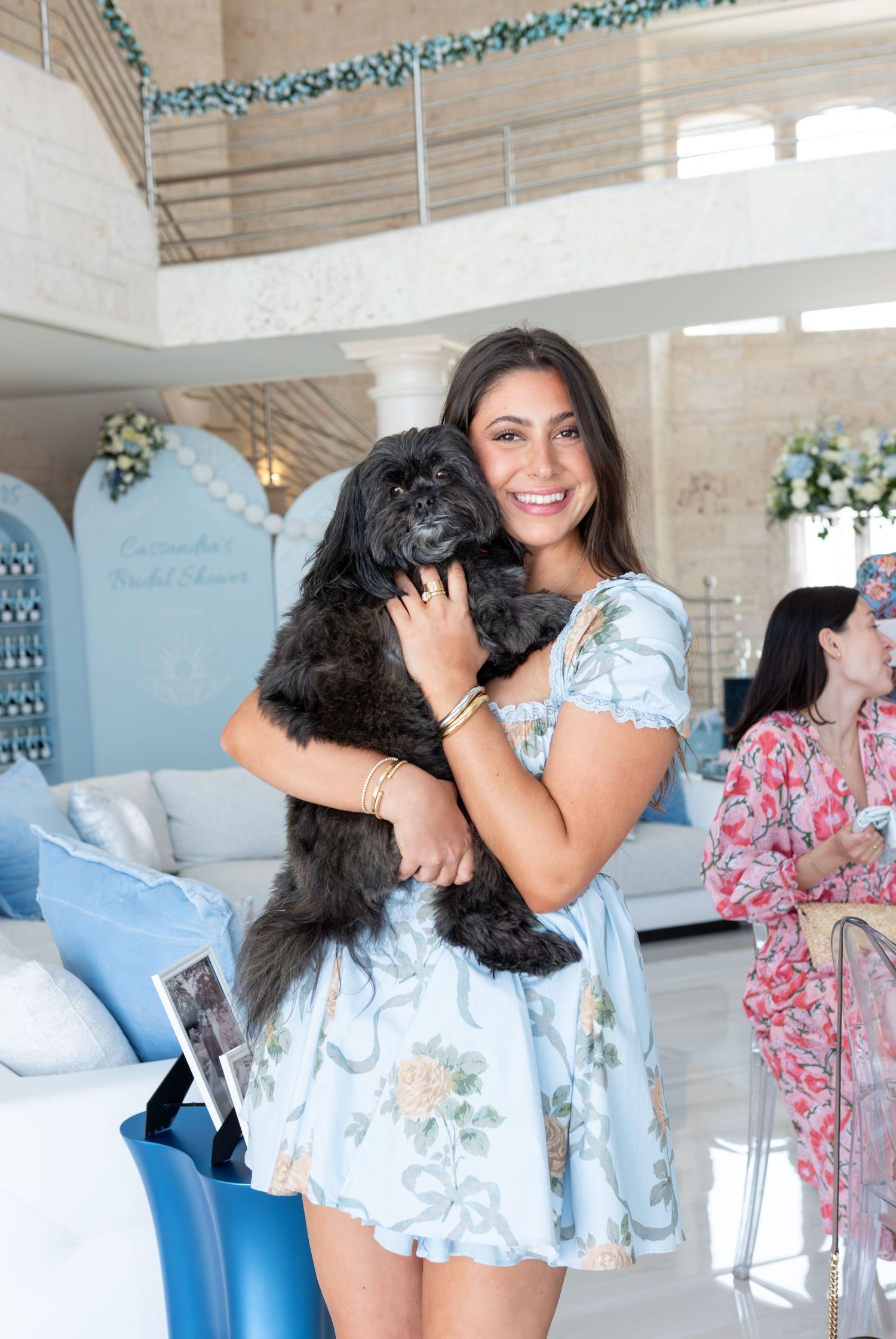 The Maid of Honor poses with her dog at a bridal shower.