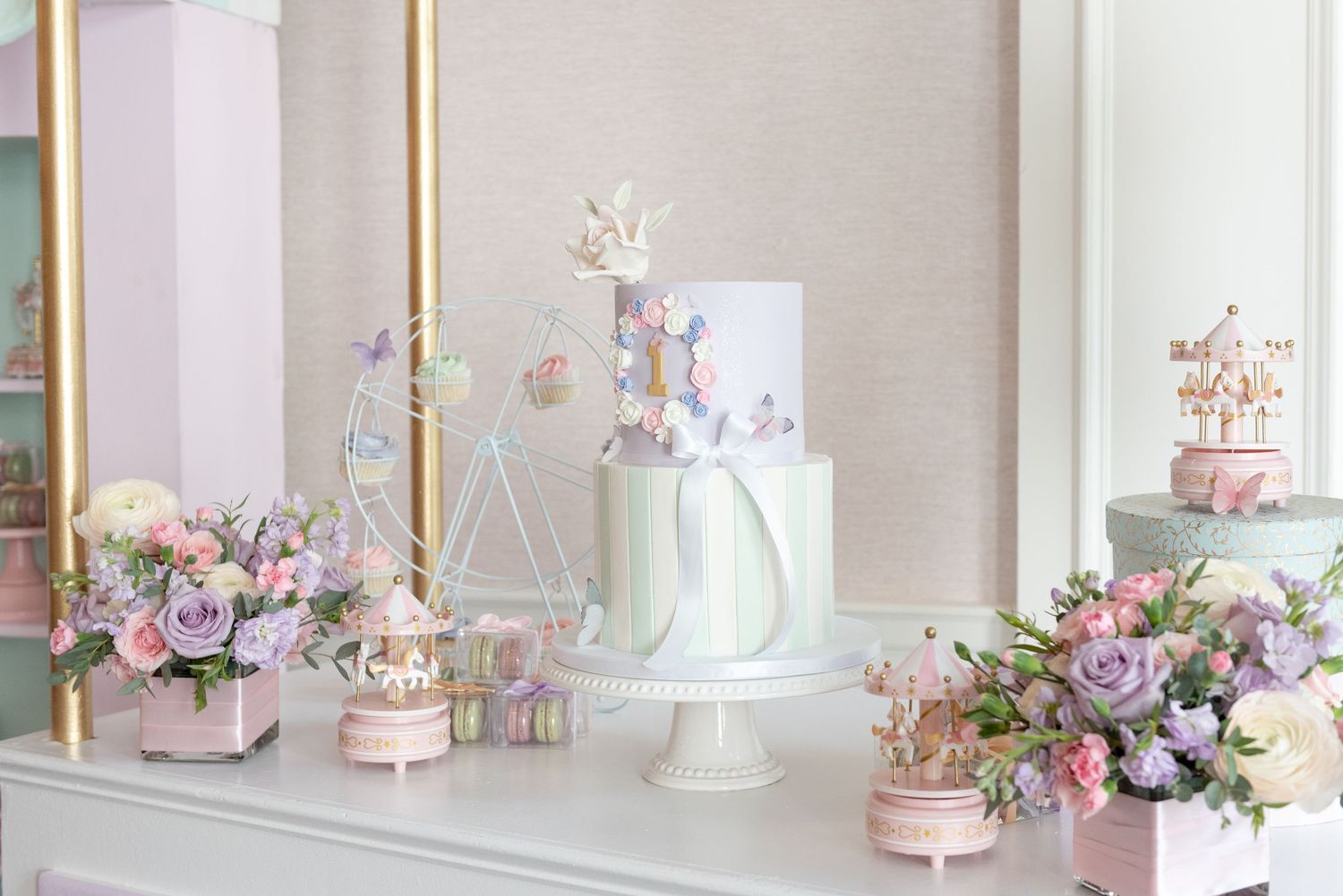 Elegant pink and white cakes with floral decorations displayed on a white dessert table with soft lighting.