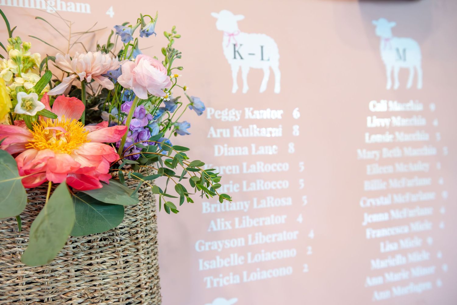 Decorative pink flowers and greenery arranged alongside our seating display with woven basket textures.