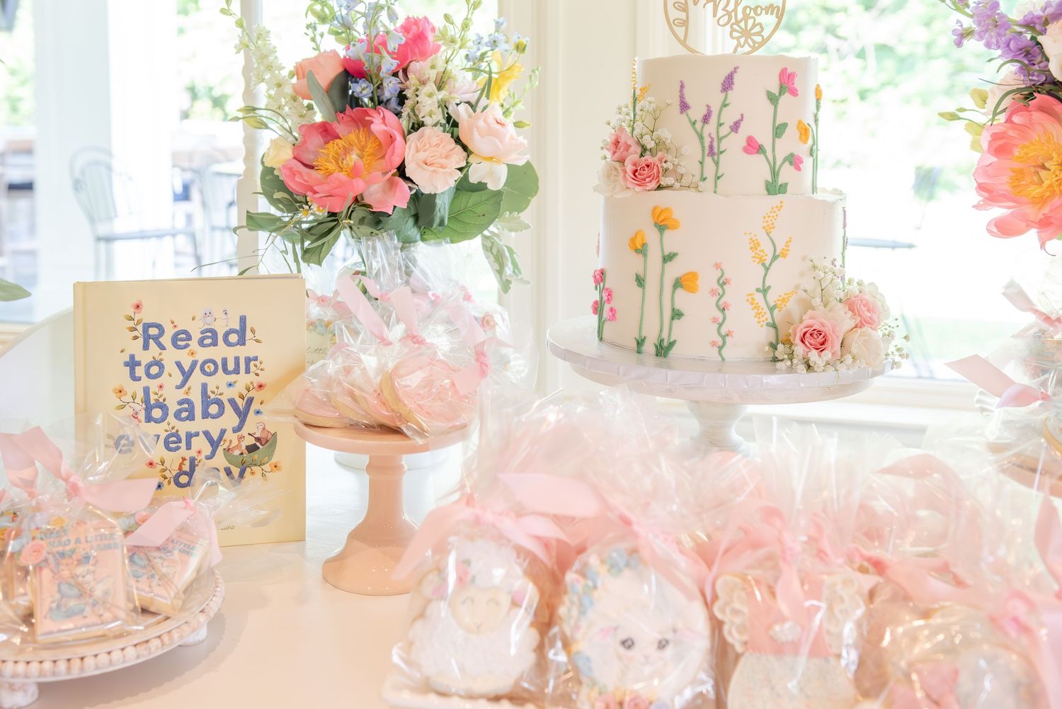 A whimsical baby shower party setup with pink and floral decorations, featuring delicate table arrangements and soft lighting.