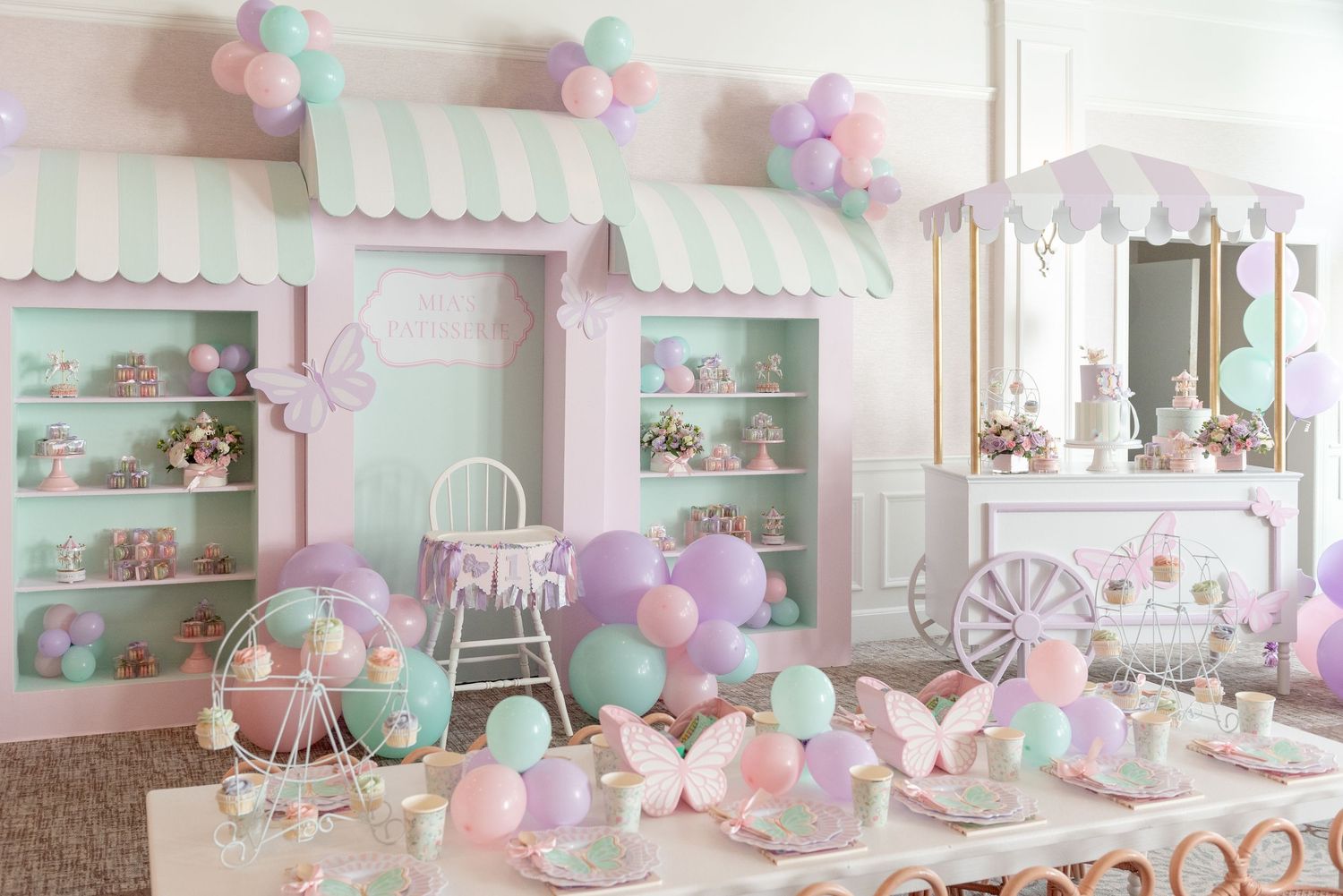 Pastel party room decorated with pink and mint balloons, shelves of treats, and whimsical decor in shabby chic style.
