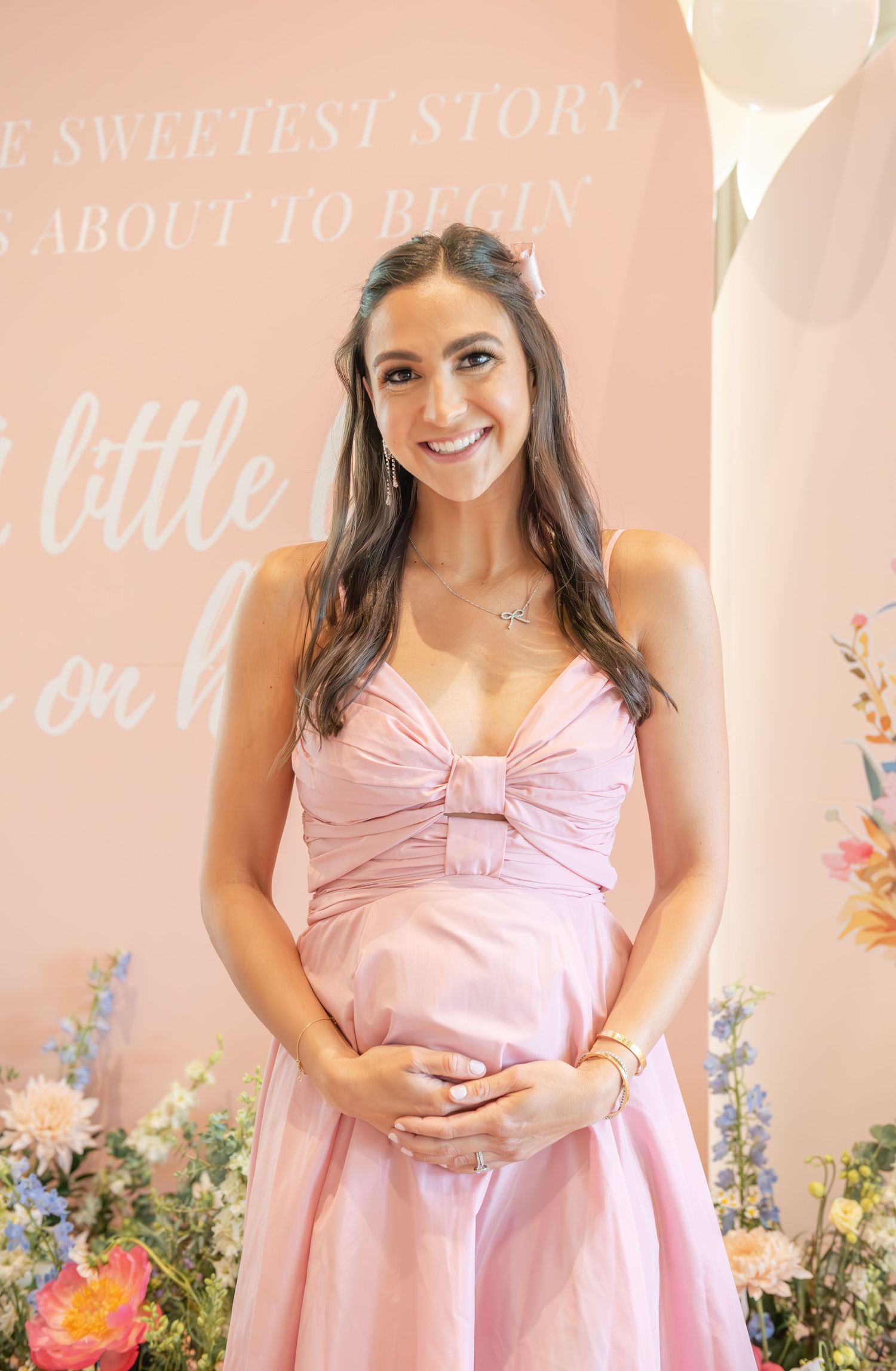 Mommy-to-be in front of her custom baby shower backdrop.