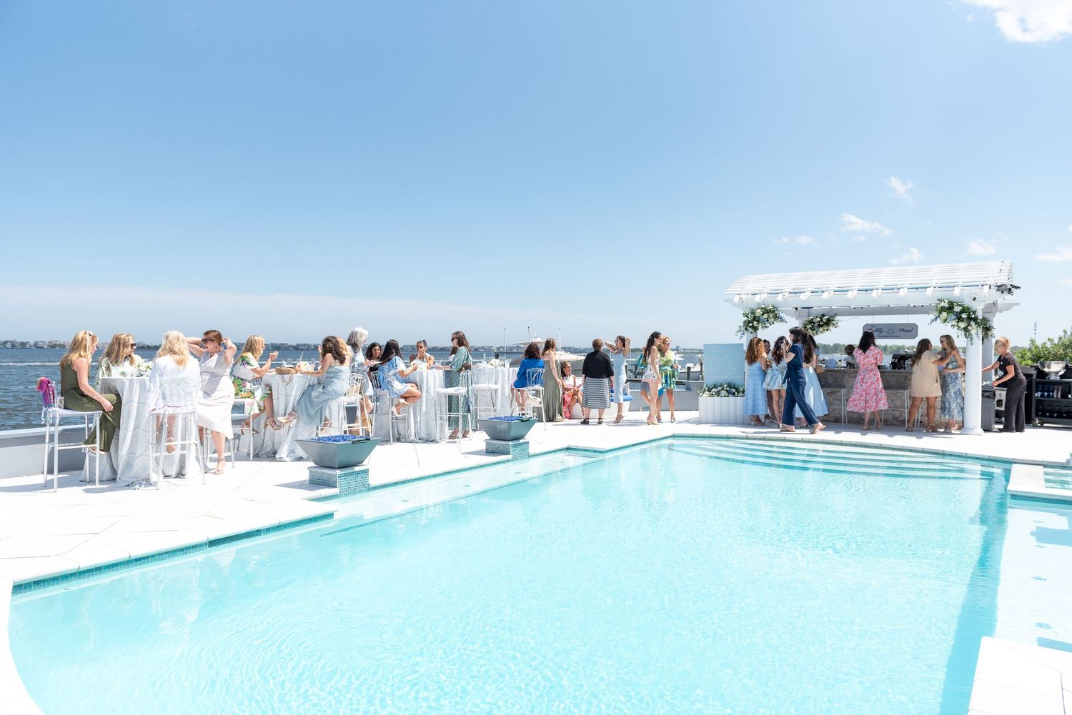 Guests enjoying the sea and the pool at a bridal shower.