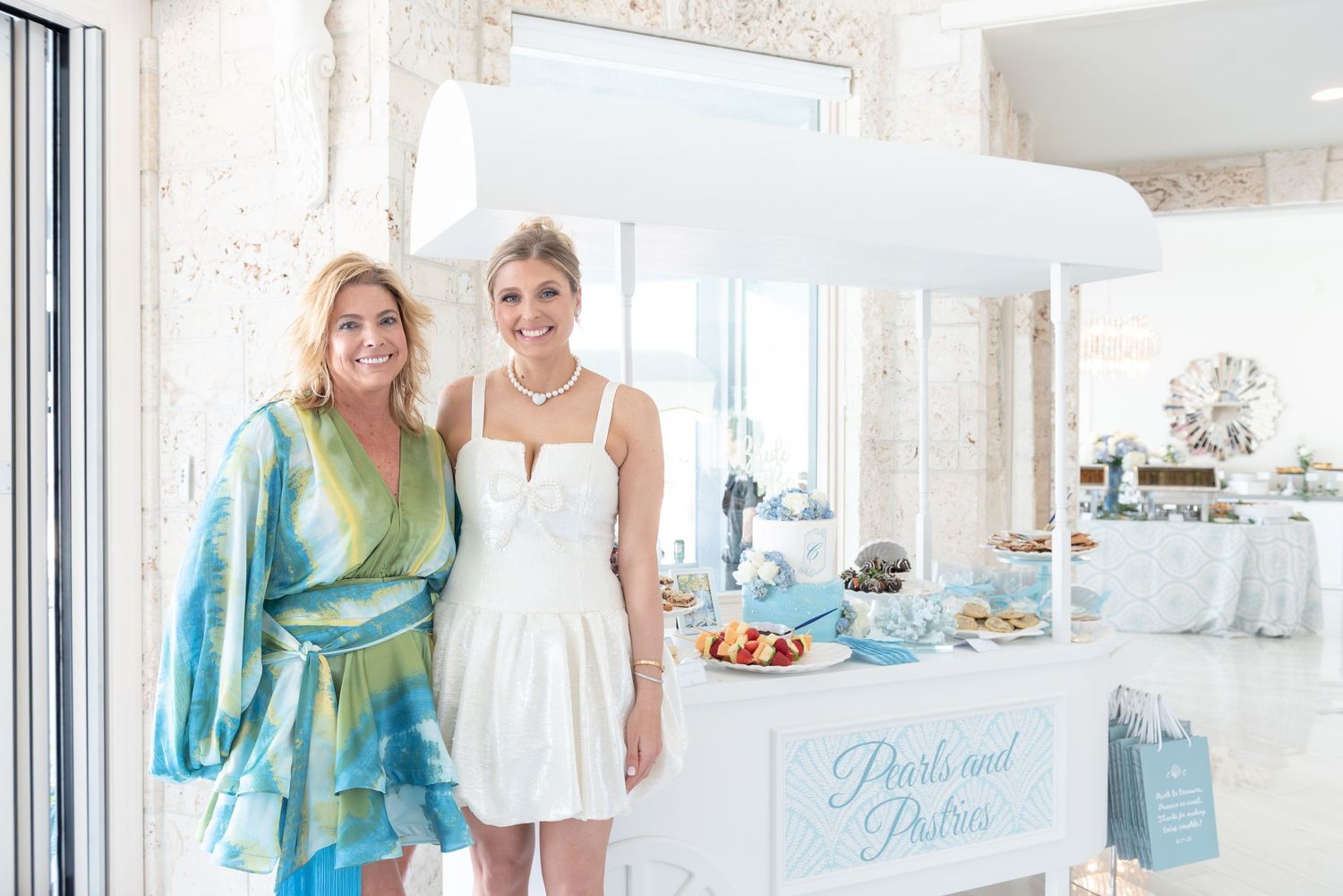 Mommy and daughter pose in front of their custom sweet cart at a bridal shower.
