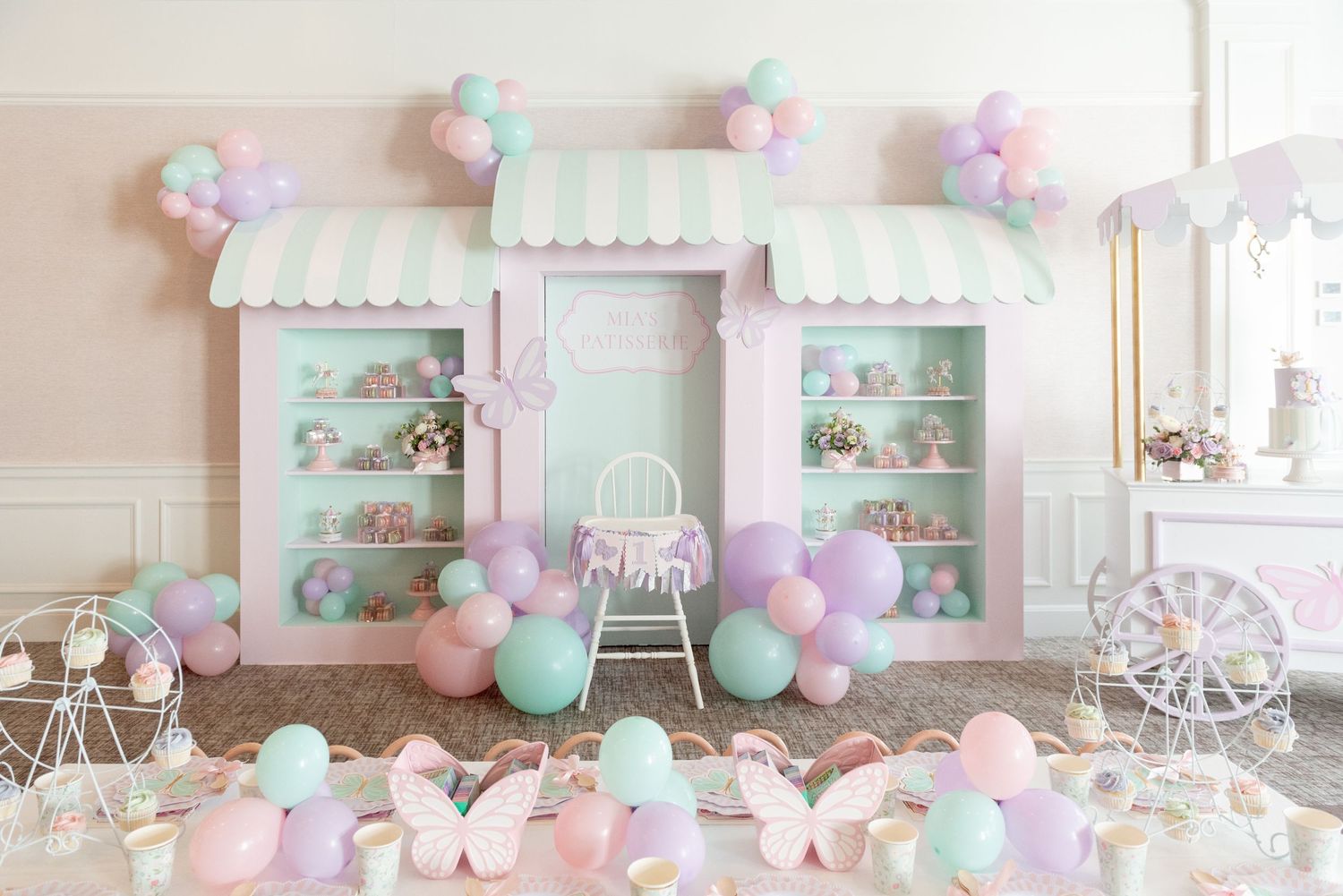 Pastel pink and mint green party decorations with balloons and vintage decor create a dreamy baby shower setting.