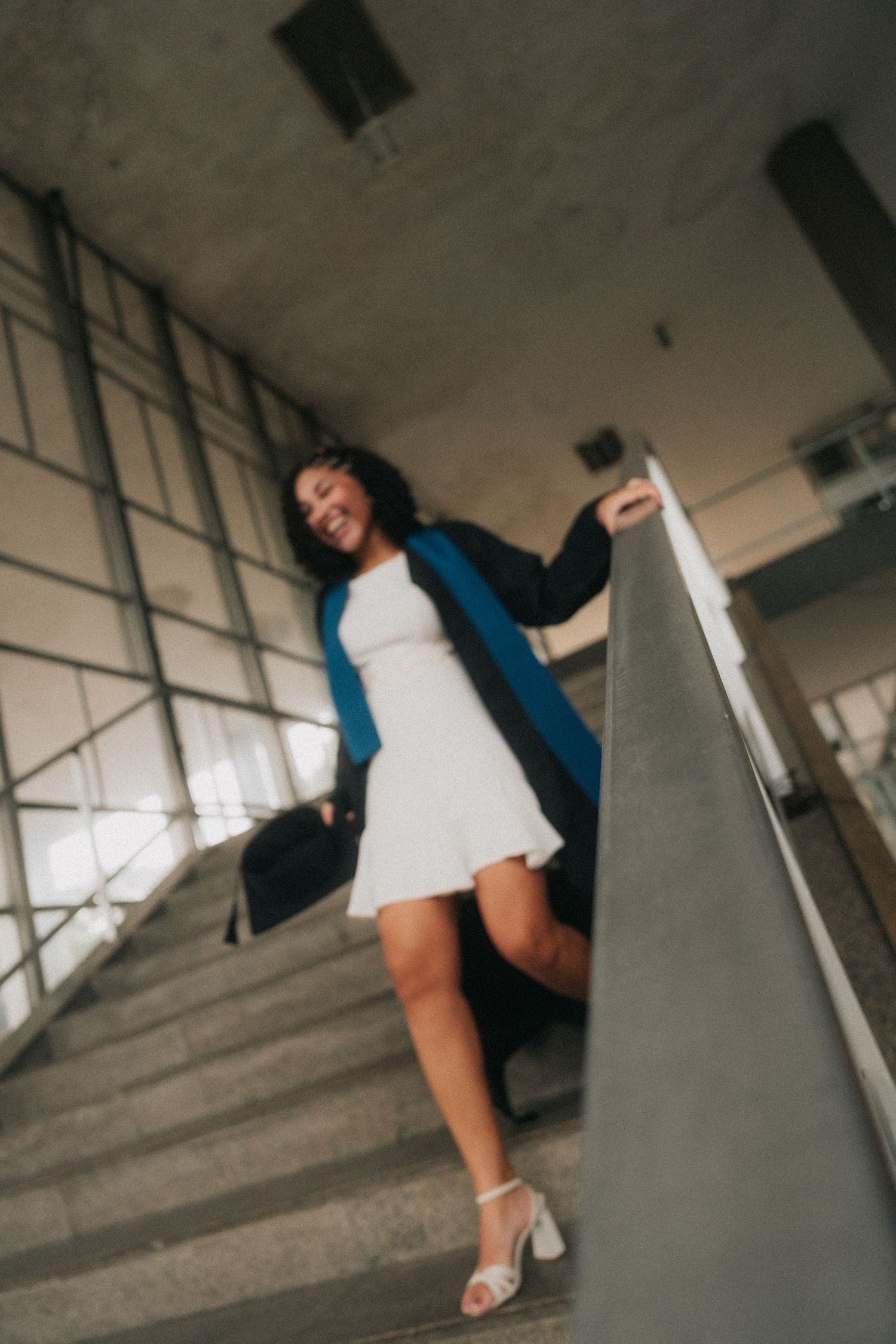Contemporary dance pose against concrete walls in an urban setting with stark lighting and dramatic angles.