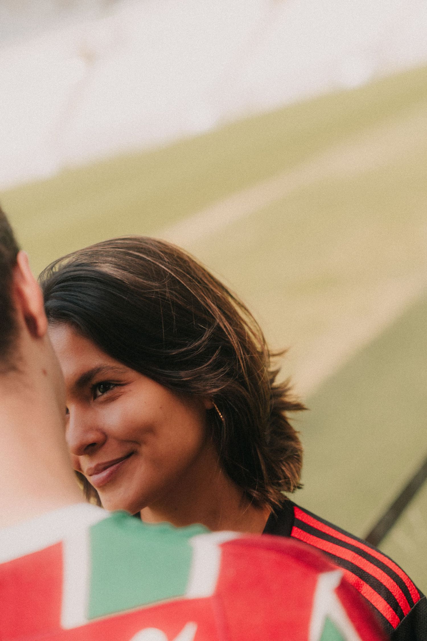 Team member in red sports jersey laughing with natural looking expression during casual moment.