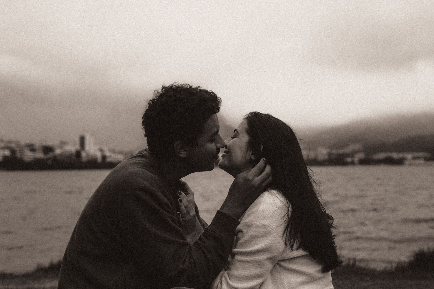A romantic black and white photo series shows couples embracing near the ocean at sunset.