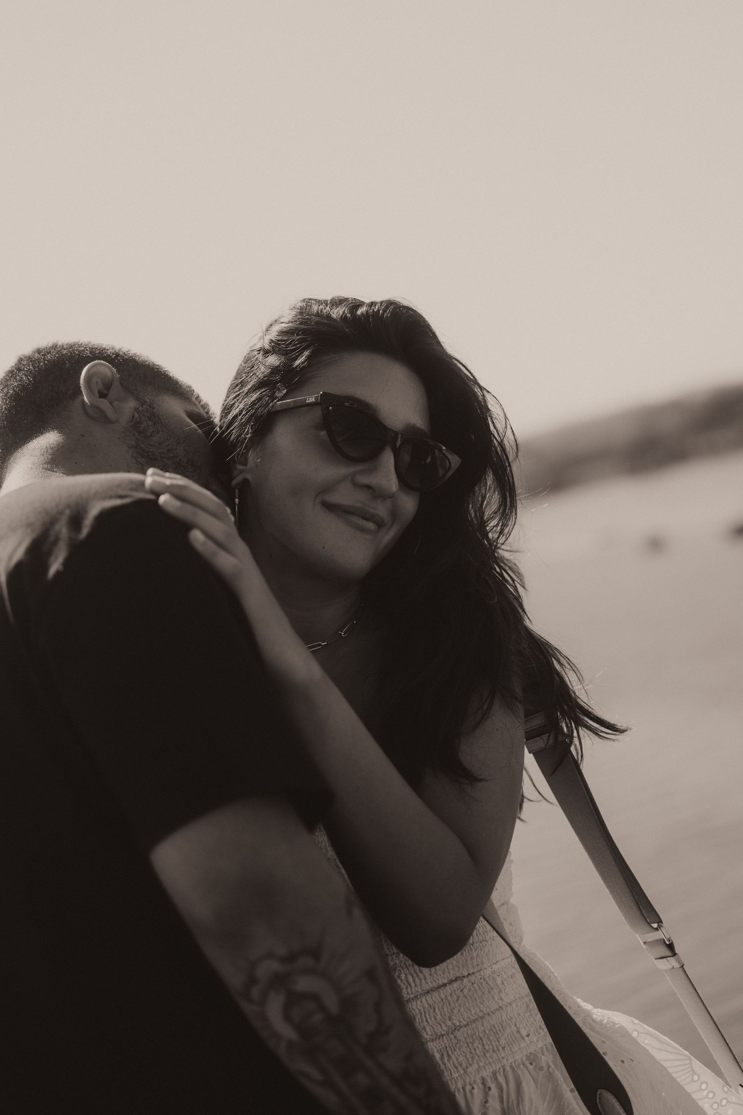 A romantic black and white photo sequence showing an intimate embrace and carefree moments outdoors.