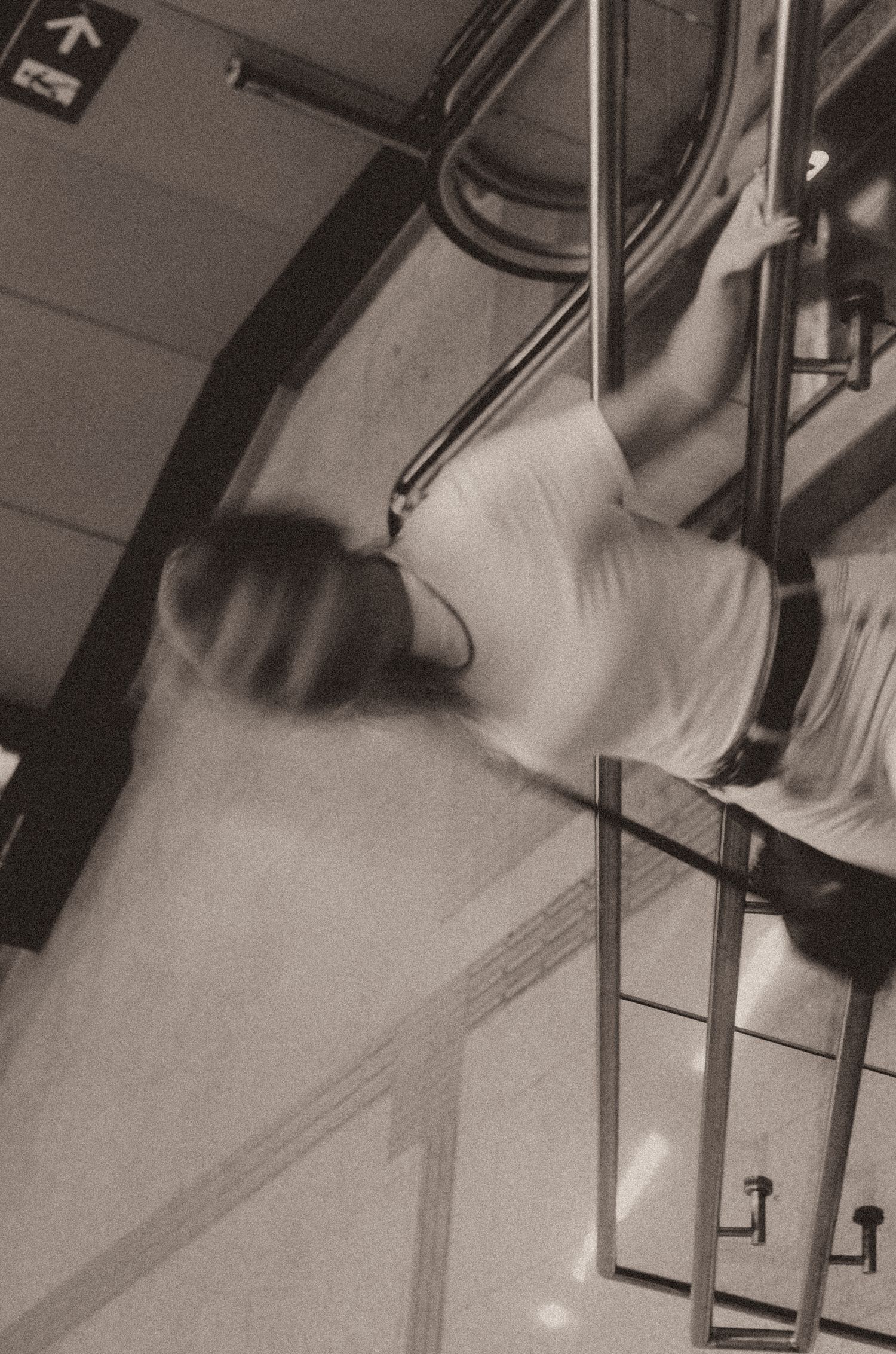 Black and white photograph of a blurred ghostly flowing white sheet or fabric creating an ethereal movement effect.