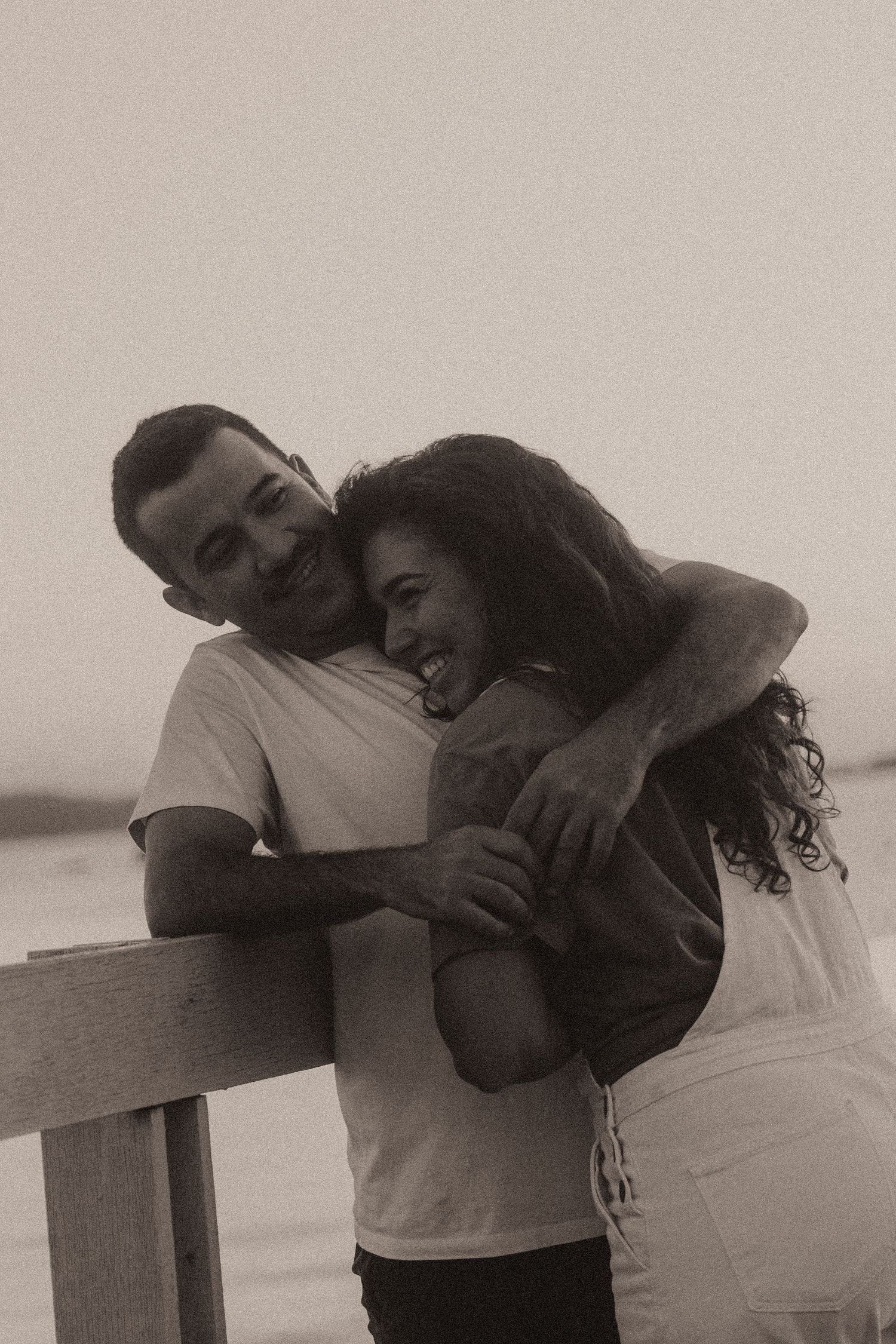 A tender black and white photo sequence showing an intimate embrace between two people against a minimal backdrop.