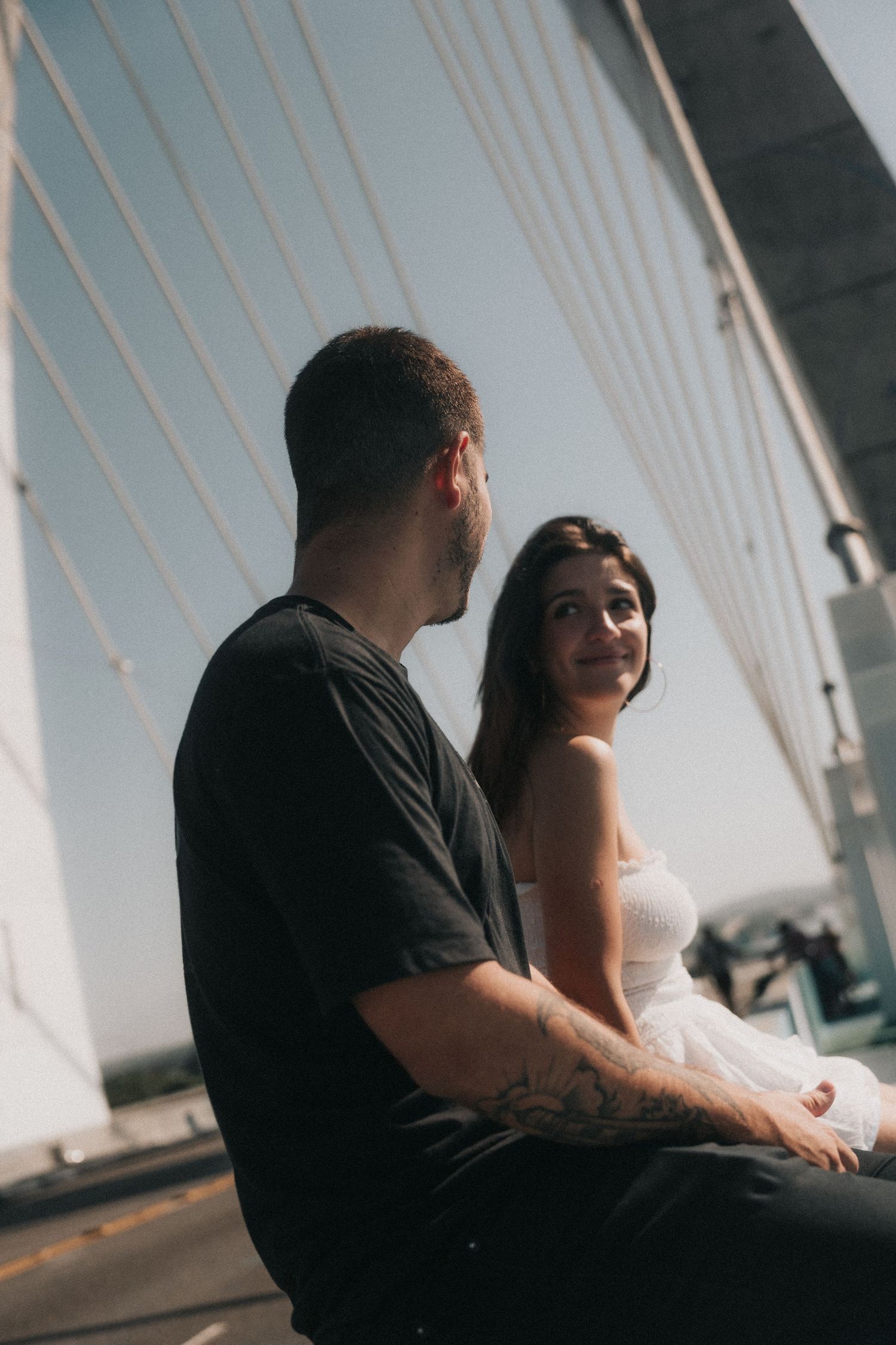A silhouetted couple sits together by white architectural beams in five sequential romantic images.