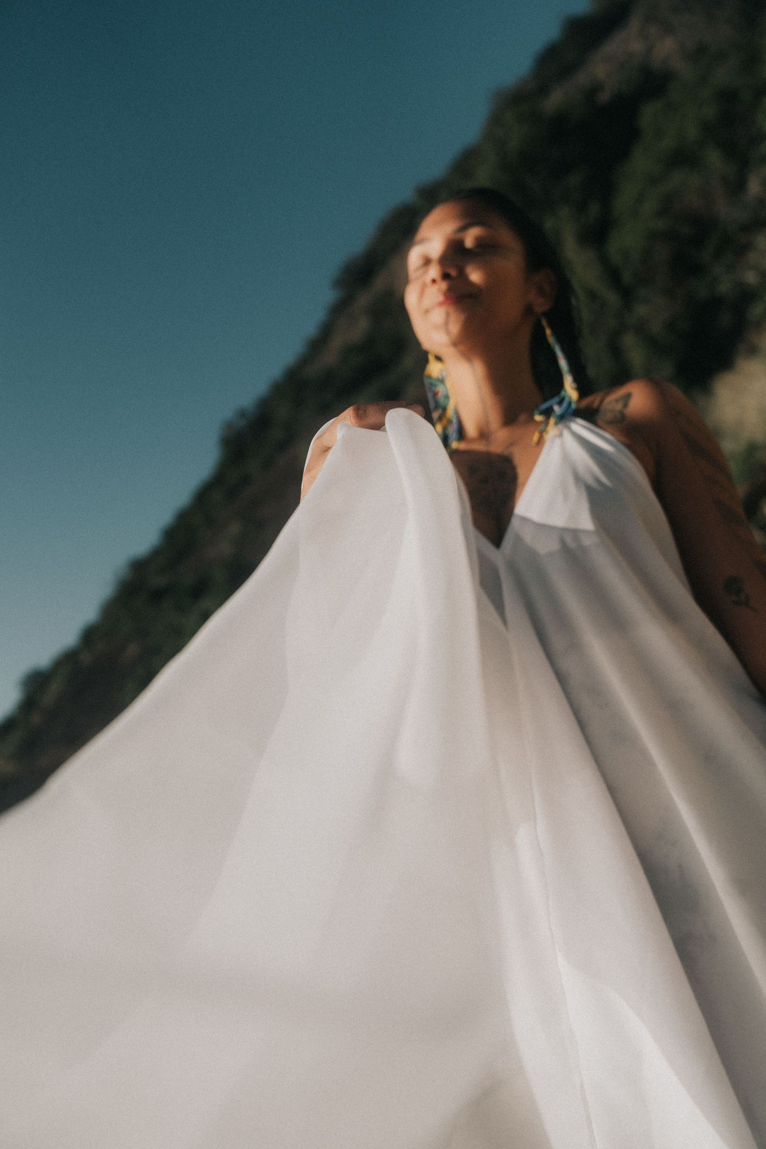 A flowing white wedding dress fabric billows gracefully in the wind across multiple sequential photos outdoors.
