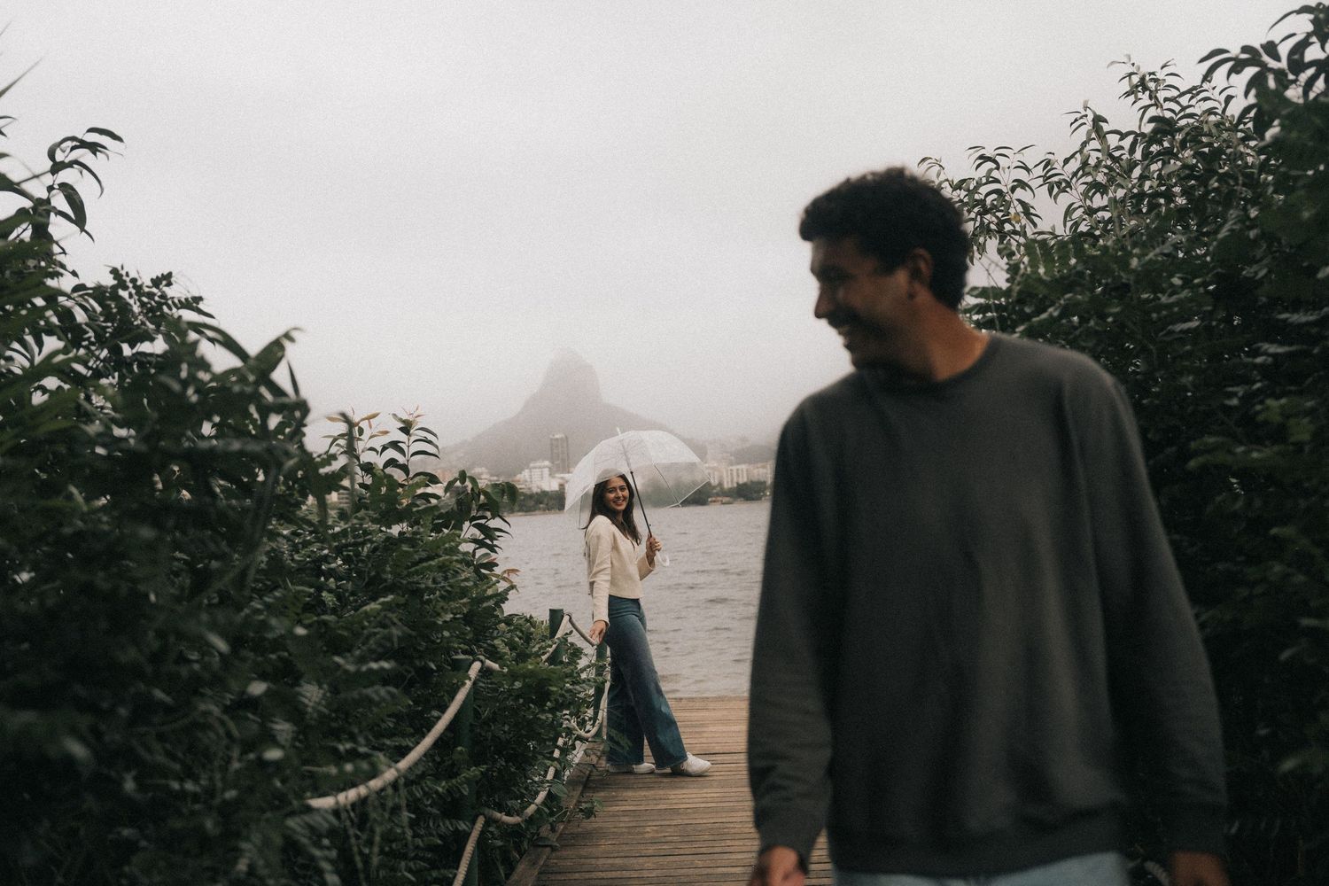 People enjoying a serene hike along a scenic trail in a coastal mountain landscape at sunset.