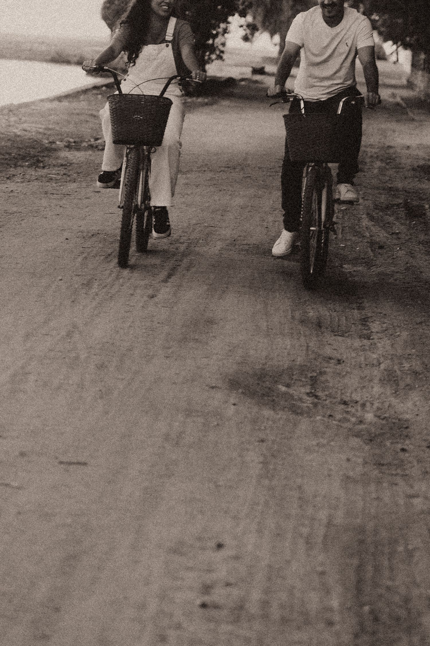 People ride bicycles on a dirt road in a series of vintage black and white photographs arranged in a strip format.