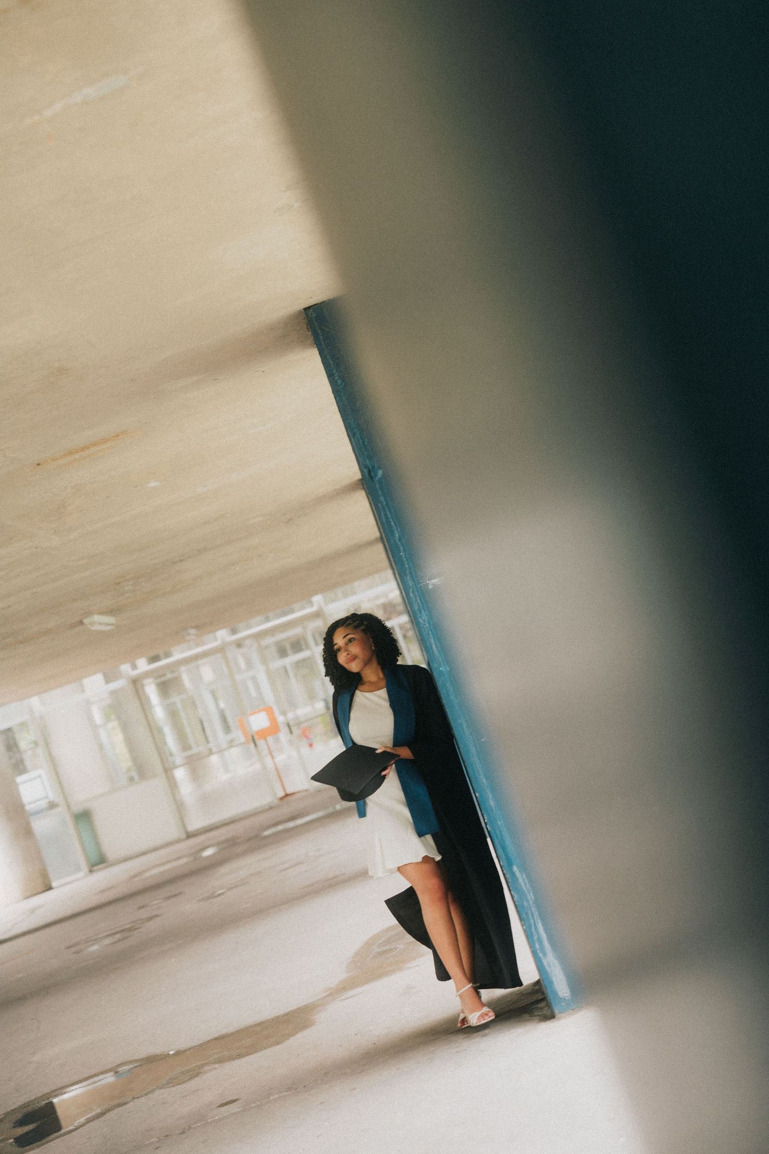 Abstract photo series capturing solo figure in dark clothing against light concrete walls in parking structure.