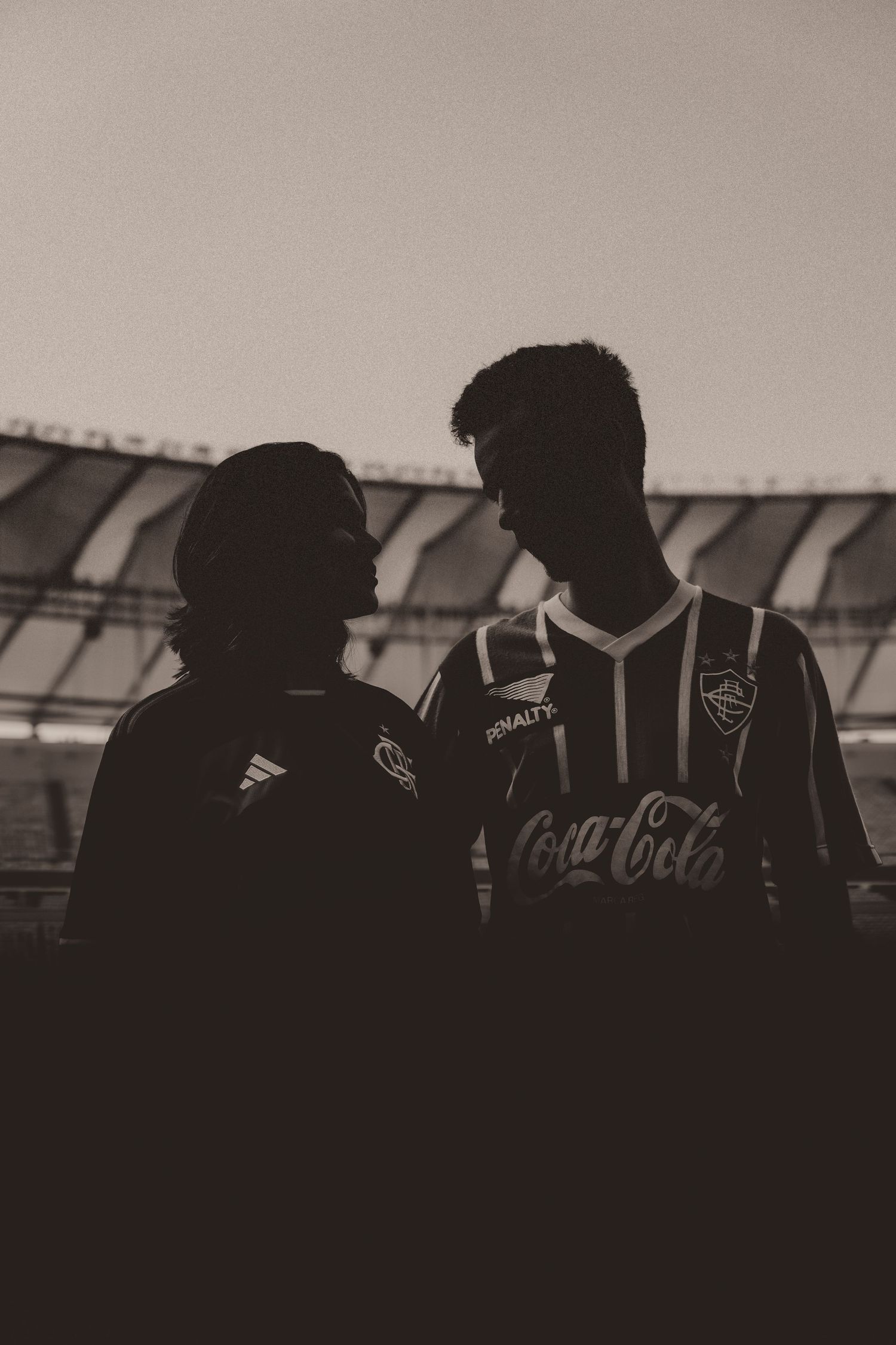 A silhouetted group of soccer players standing in dark jerseys against a light background.