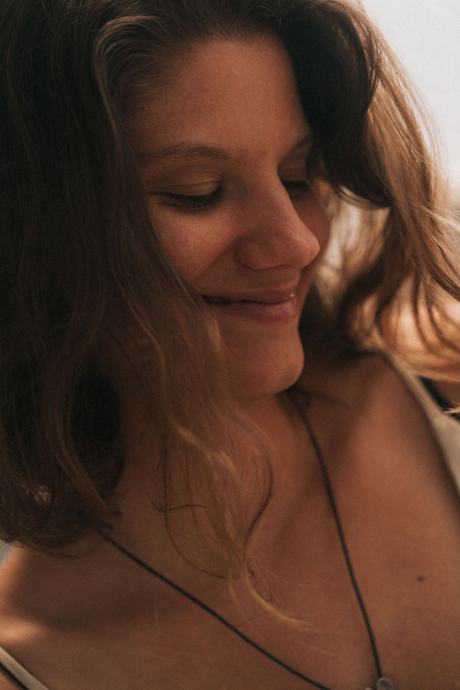 A sequence of intimate close-up portraits showing gentle smiles and flowing brown hair in warm lighting.