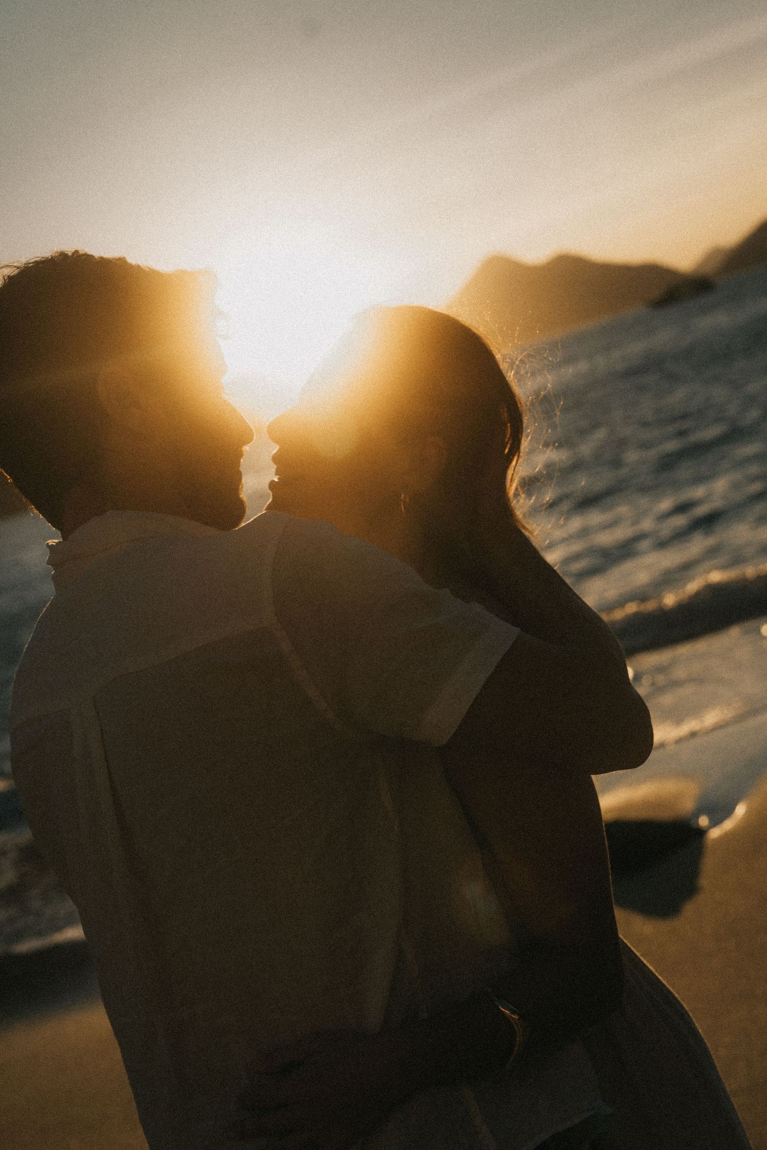 Romantic couple silhouettes against ocean sunset create a dreamy series of intimate beach photographs.