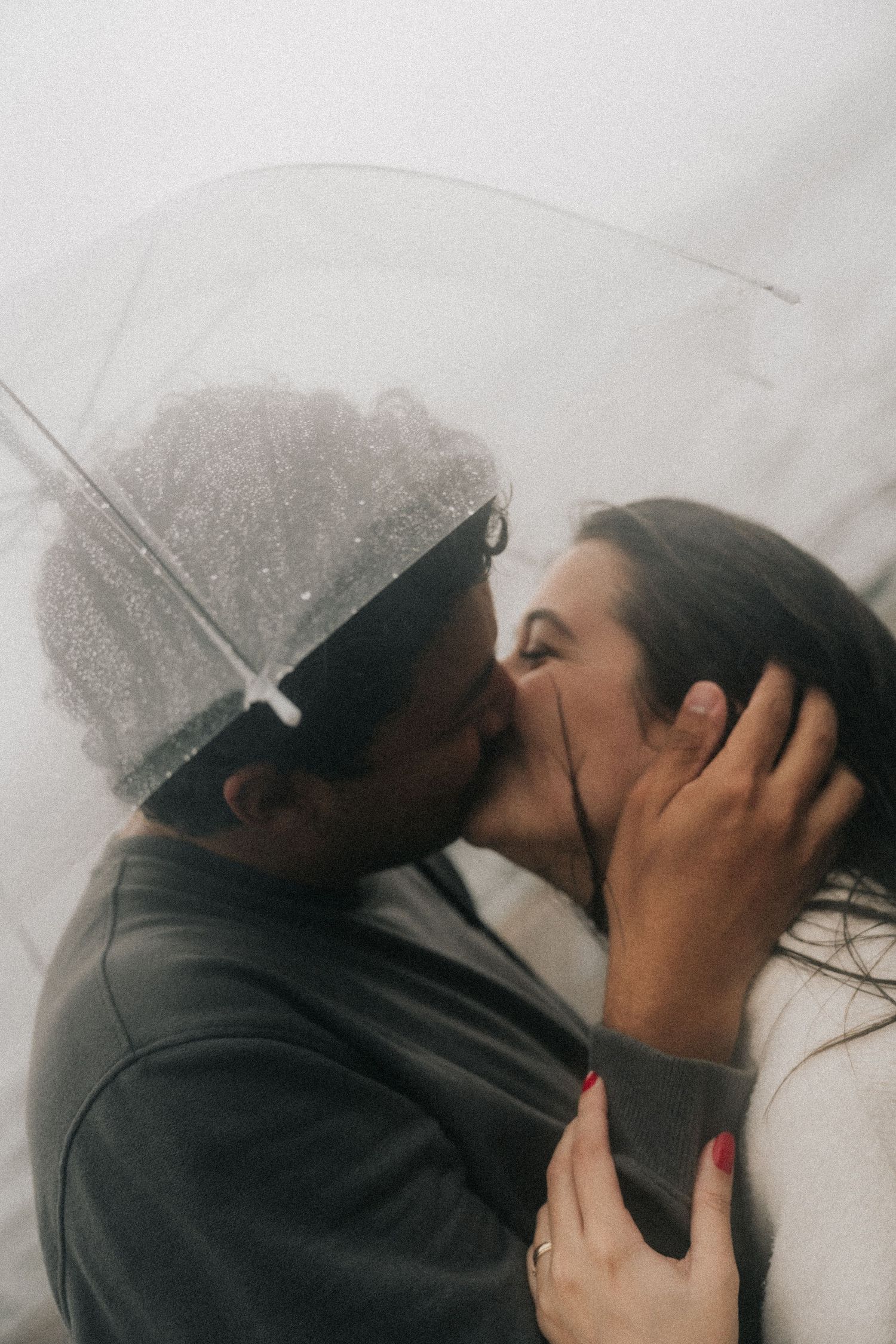 A series of romantic photos showing a couple kissing under clear umbrellas in the rain.