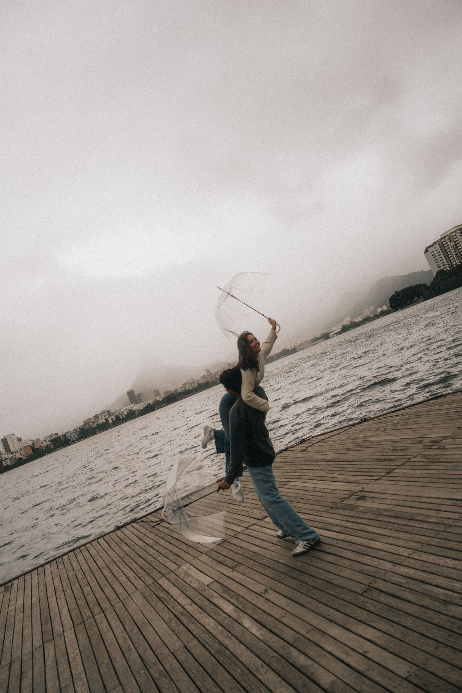 Multiple sequential frames show someone practicing ballet spins on a wooden pier over water on an overcast day.