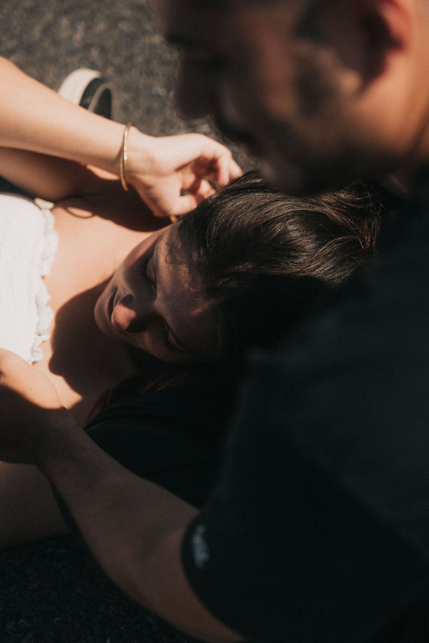 Intimate close-up shot of a romantic couple sharing a passionate kiss against a dark background.
