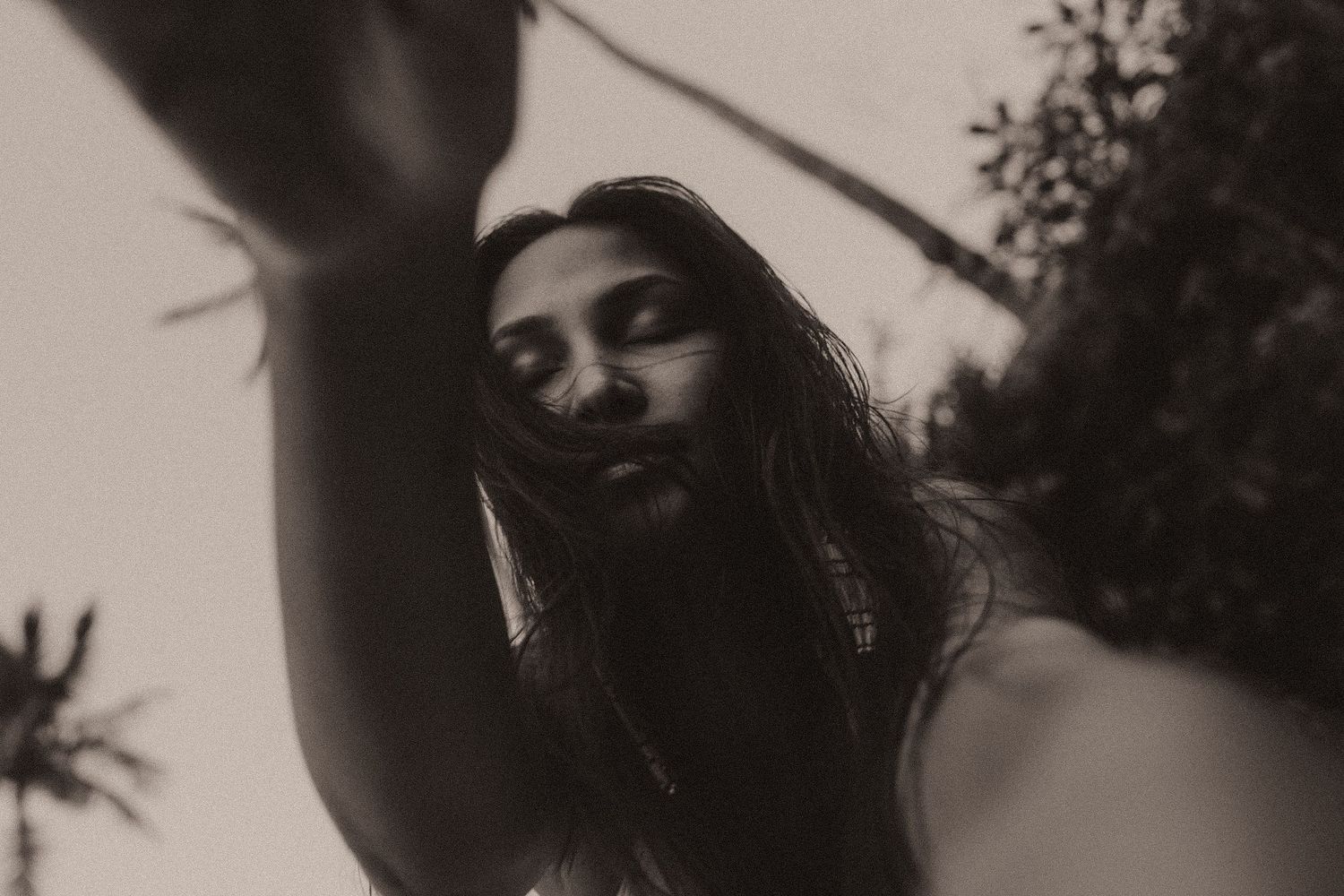 Woman underwater with long dark hair flowing freely in black and white photography.