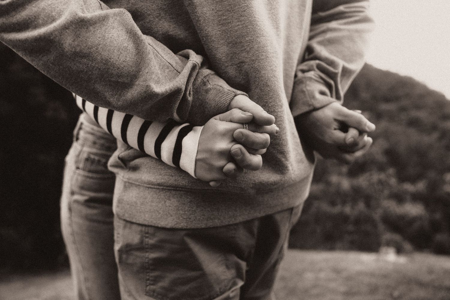 A series of black and white photographs showing hands holding and interacting with a small puppy.