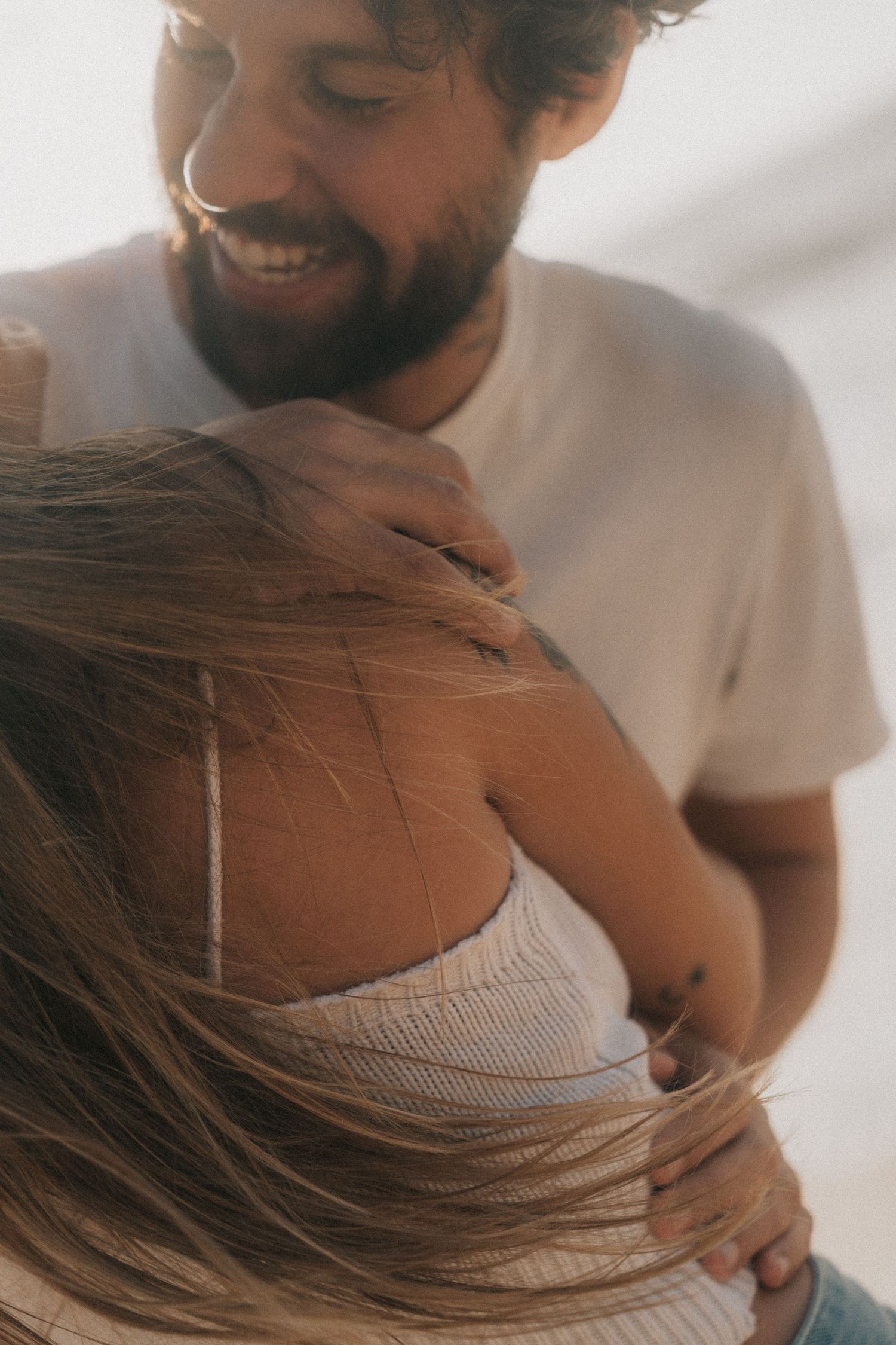 An intimate moment captured in a series of warm-toned photos showing a tender embrace in soft natural lighting.