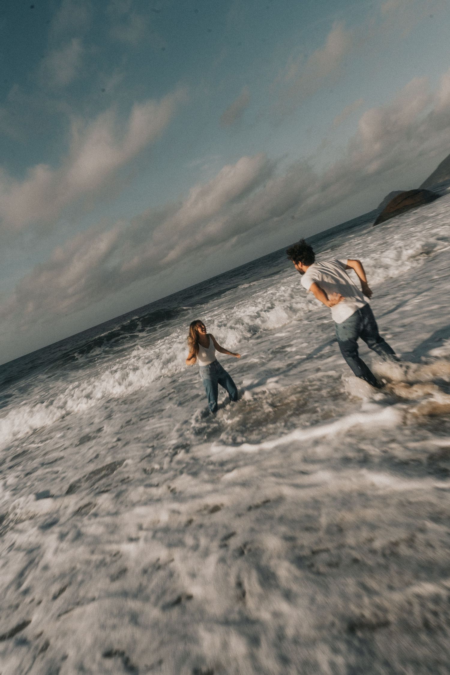 A dramatic sequence of photos capturing someone falling while surfing on ocean waves as the sun sets.