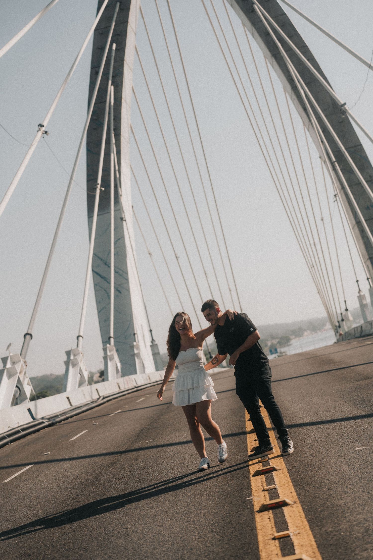 A sequence of four artistic shots showing people in motion crossing over a cable bridge with dramatic shadows.