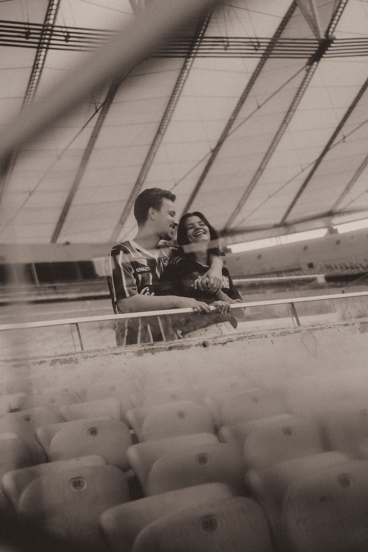 Black and white photo sequence showing people leaning over stadium seats during a sports event.