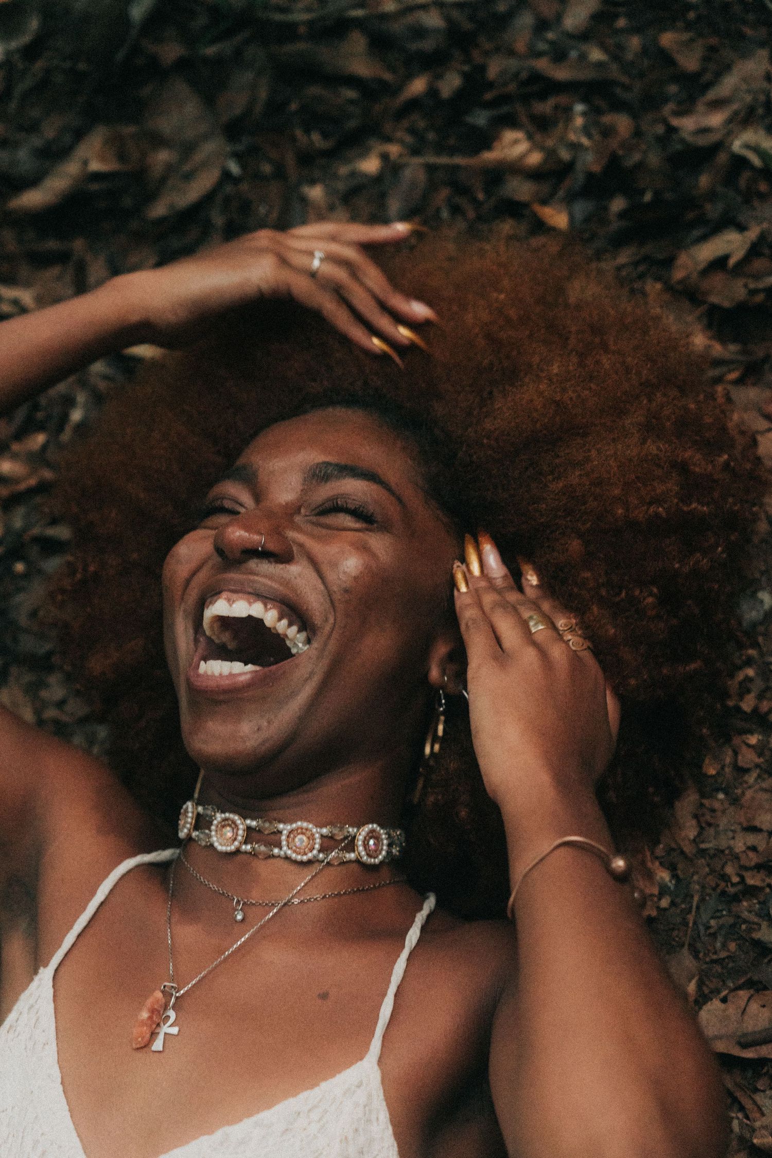 A series of joyful candid moments showing genuine laughter and natural curly hair against a dark background.