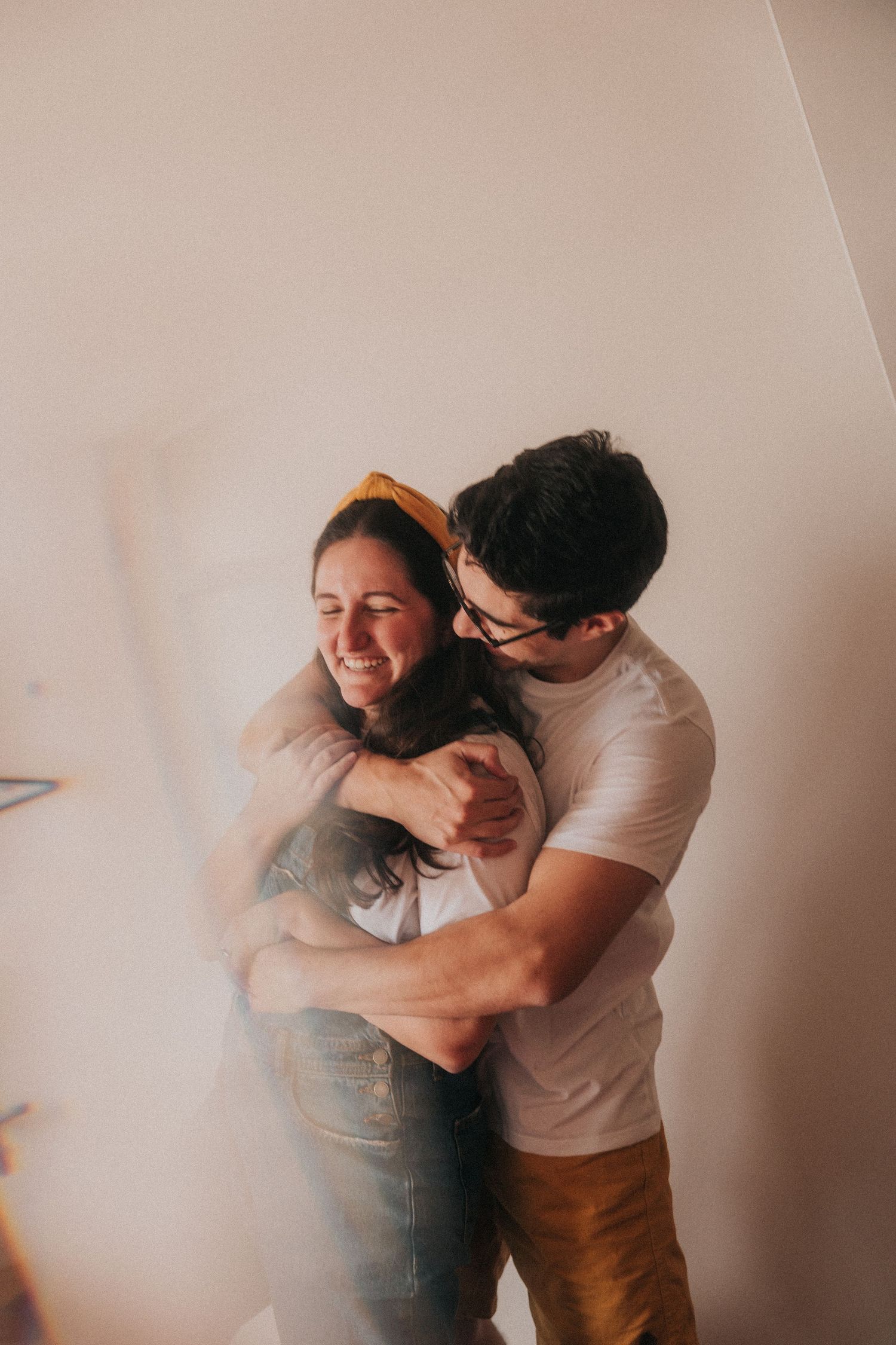 A romantic couple dancing together in a dimly lit room with dreamy, atmospheric lighting creating an intimate mood.
