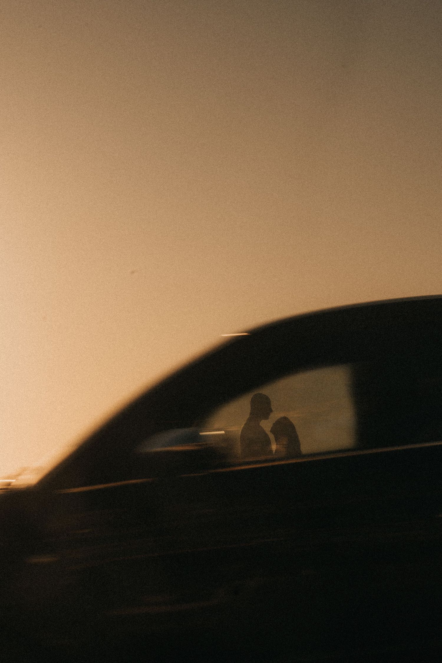 A series of silhouetted car profiles aligned horizontally against a sepia-toned background.